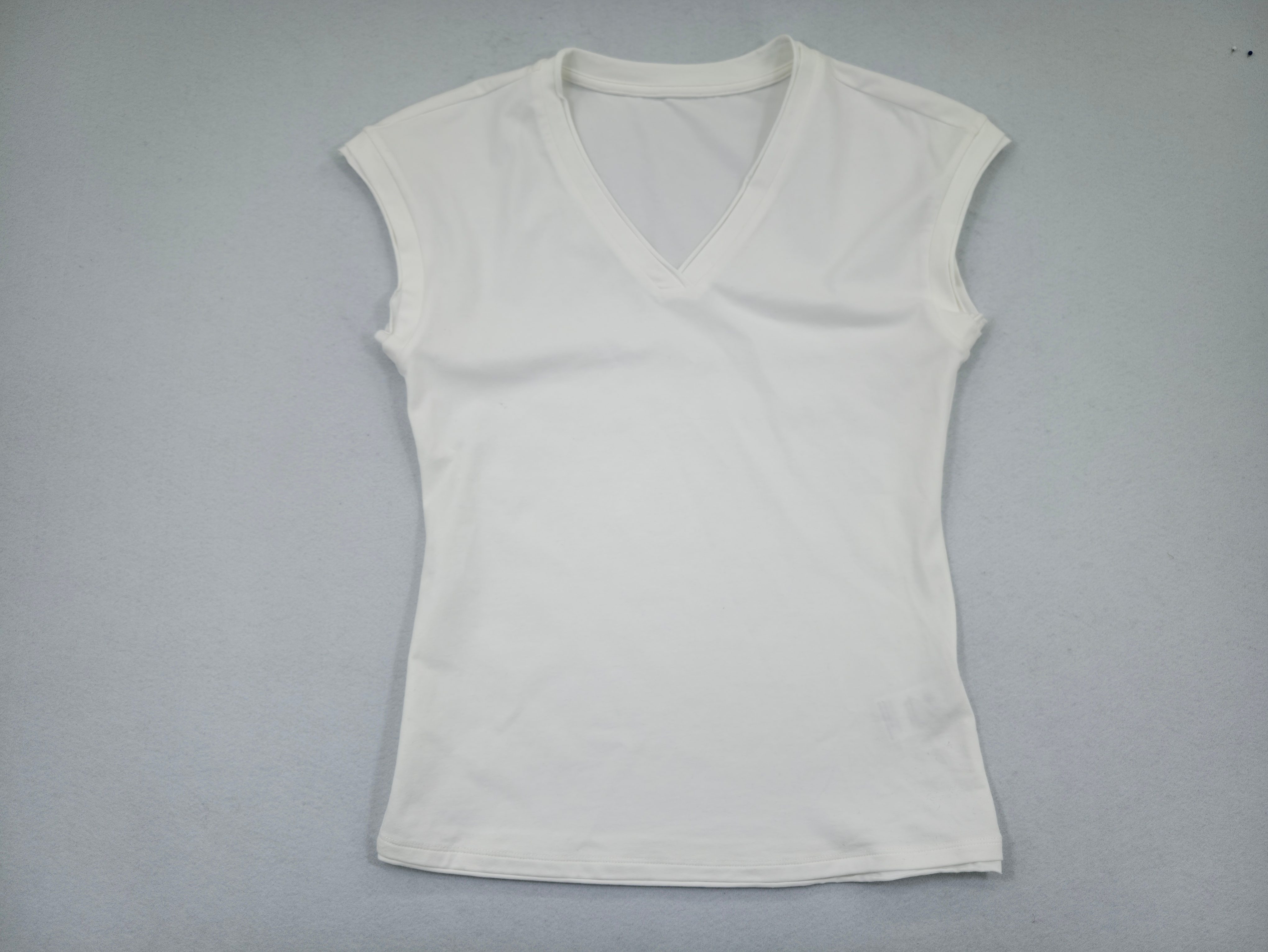 White peach-brushed V-neck sleeveless top laid flat front