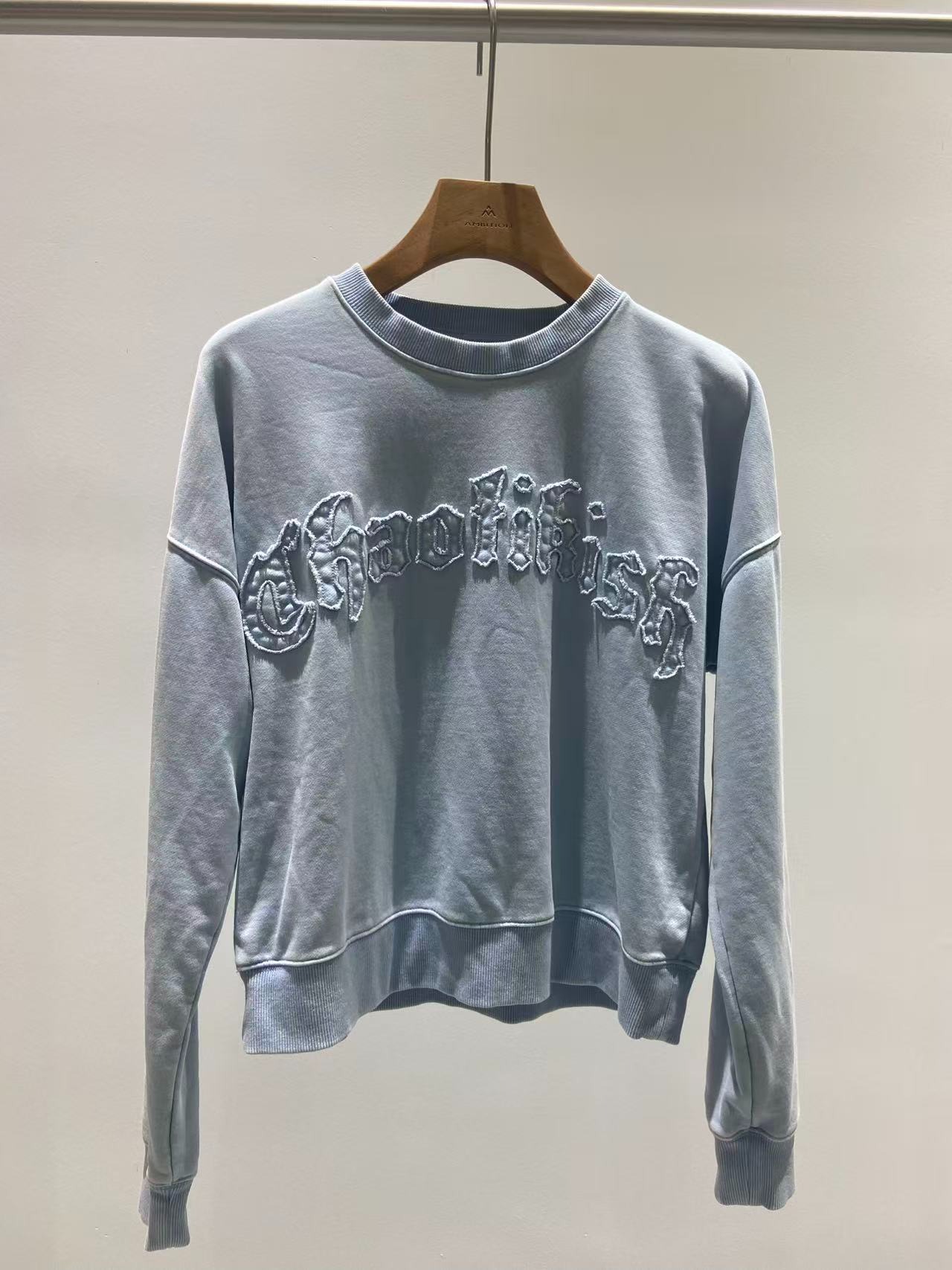 Garment-dyed blue sweatshirt with tonal chest appliqué embroidery