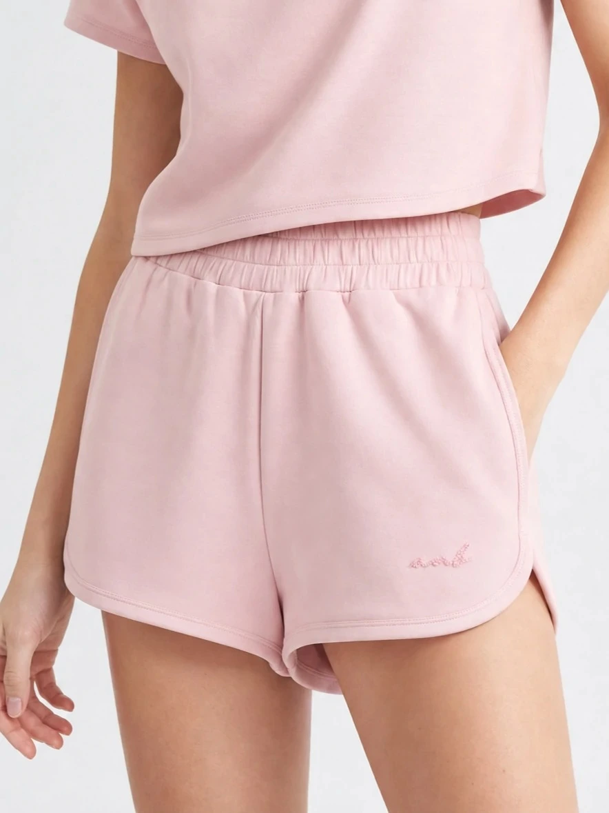Model wearing blush pink modal-blend dolphin shorts