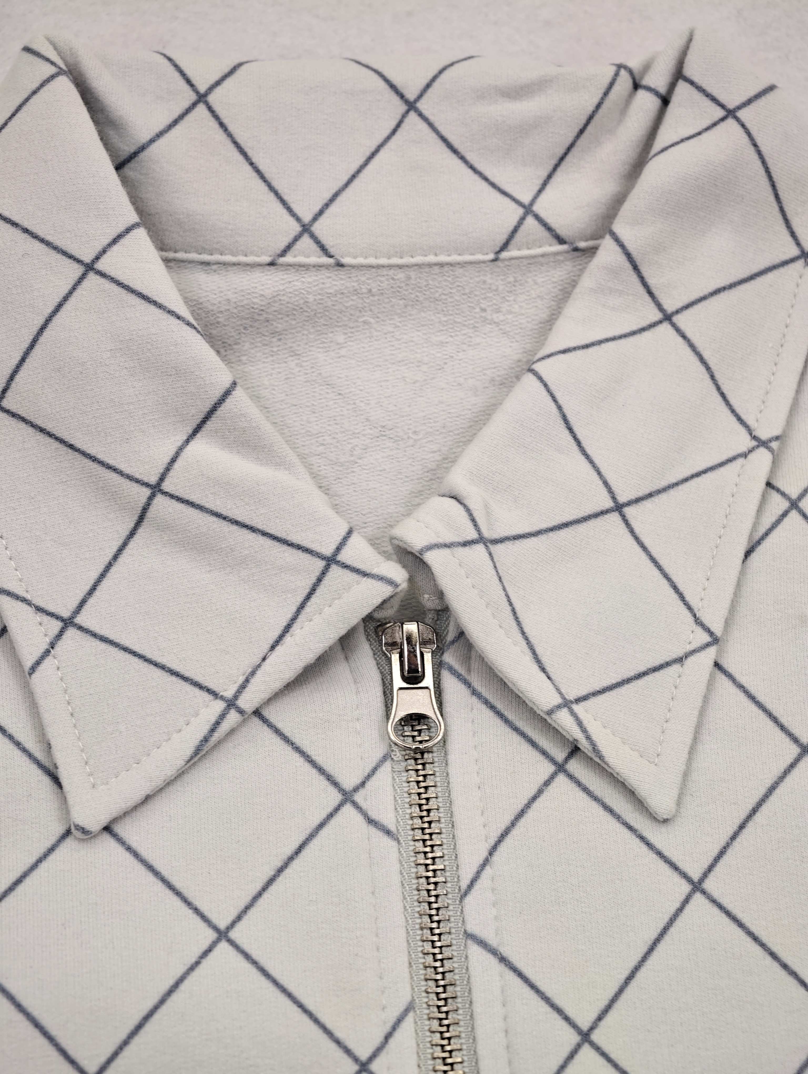 Pointed collar and metal quarter-zip fastening detail
