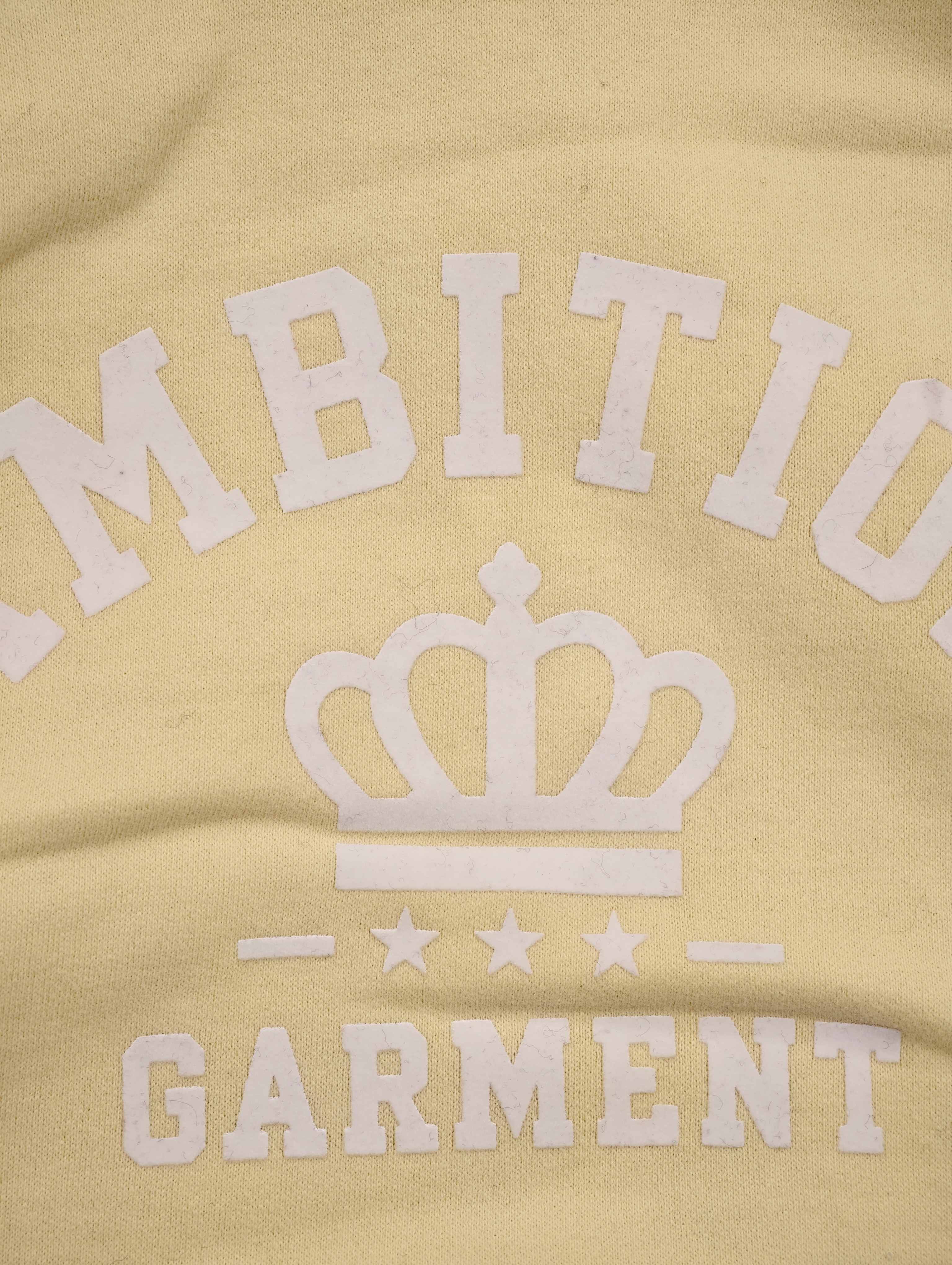 White collegiate crown graphic on yellow sweatshirt fabric
