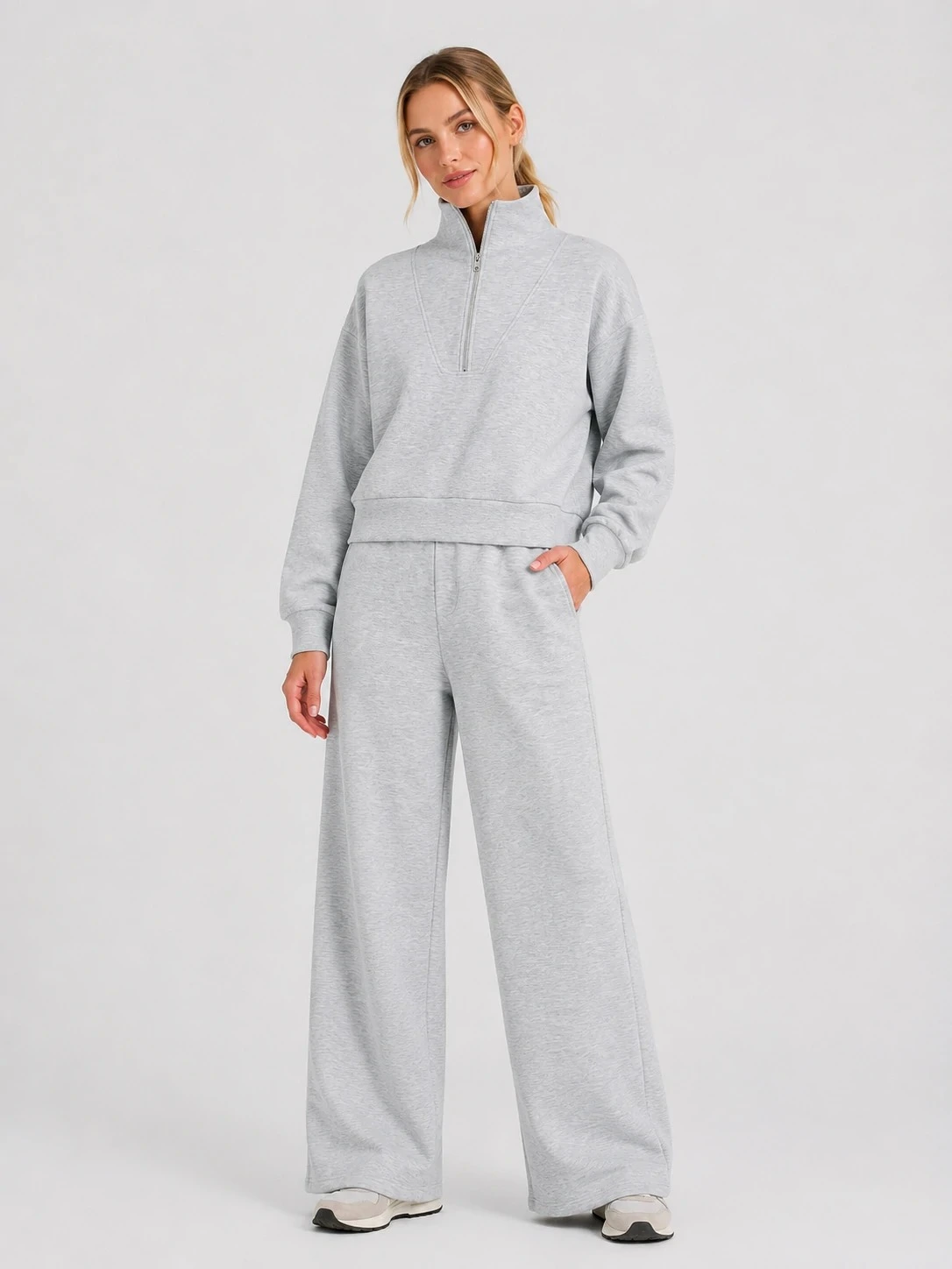 Model wearing light grey half-zip sweatshirt and wide-leg pants