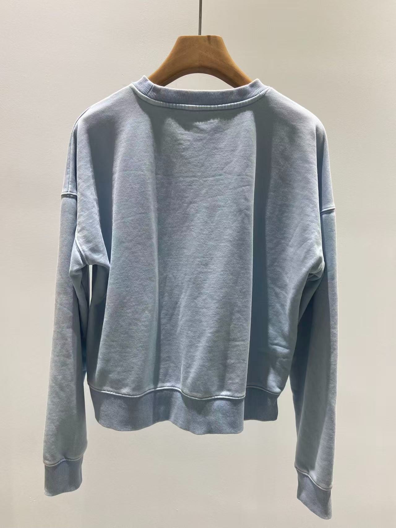 Plain back construction with ribbed neckline cuffs and hem
