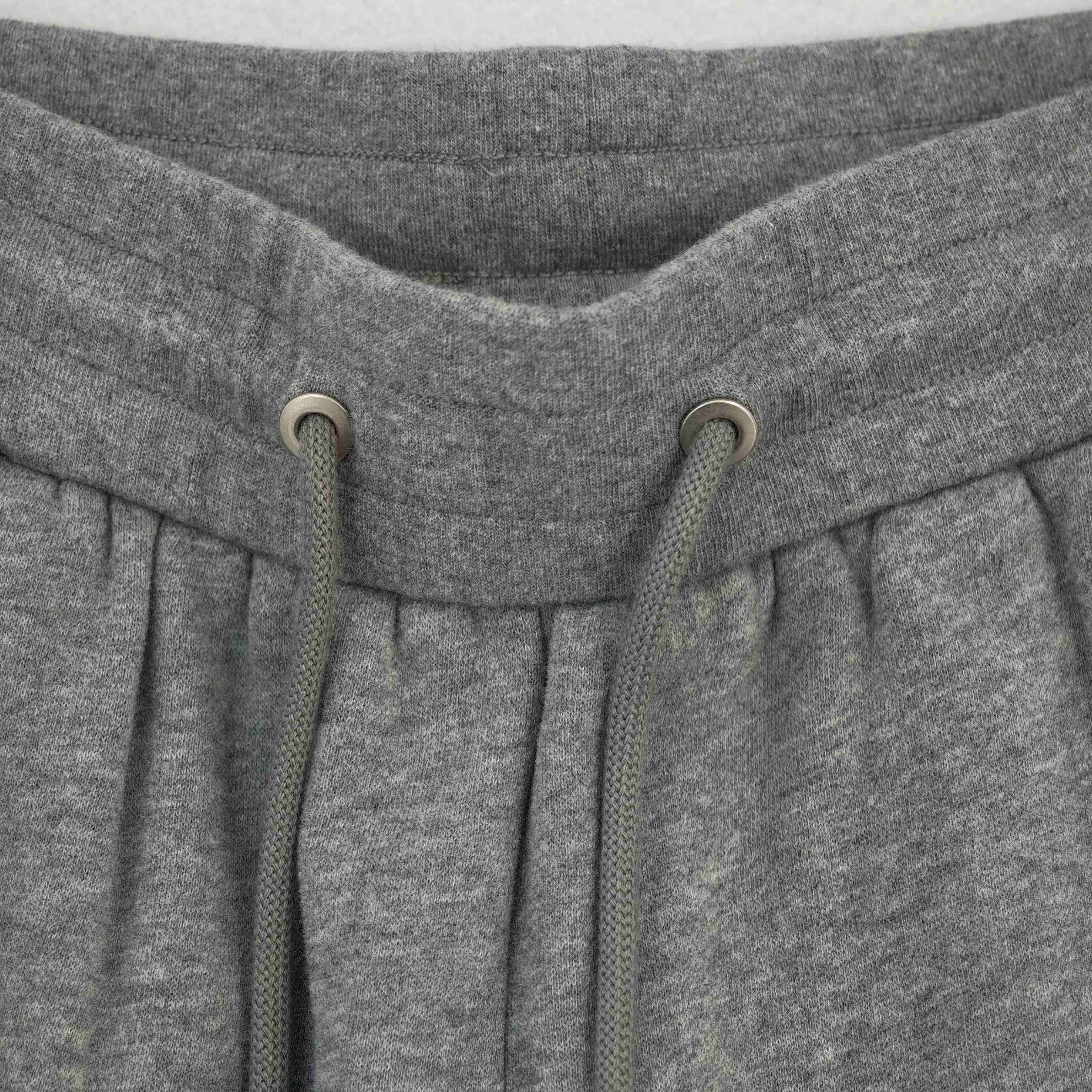 Drawstring waistband, metal eyelets and front pleats close-up