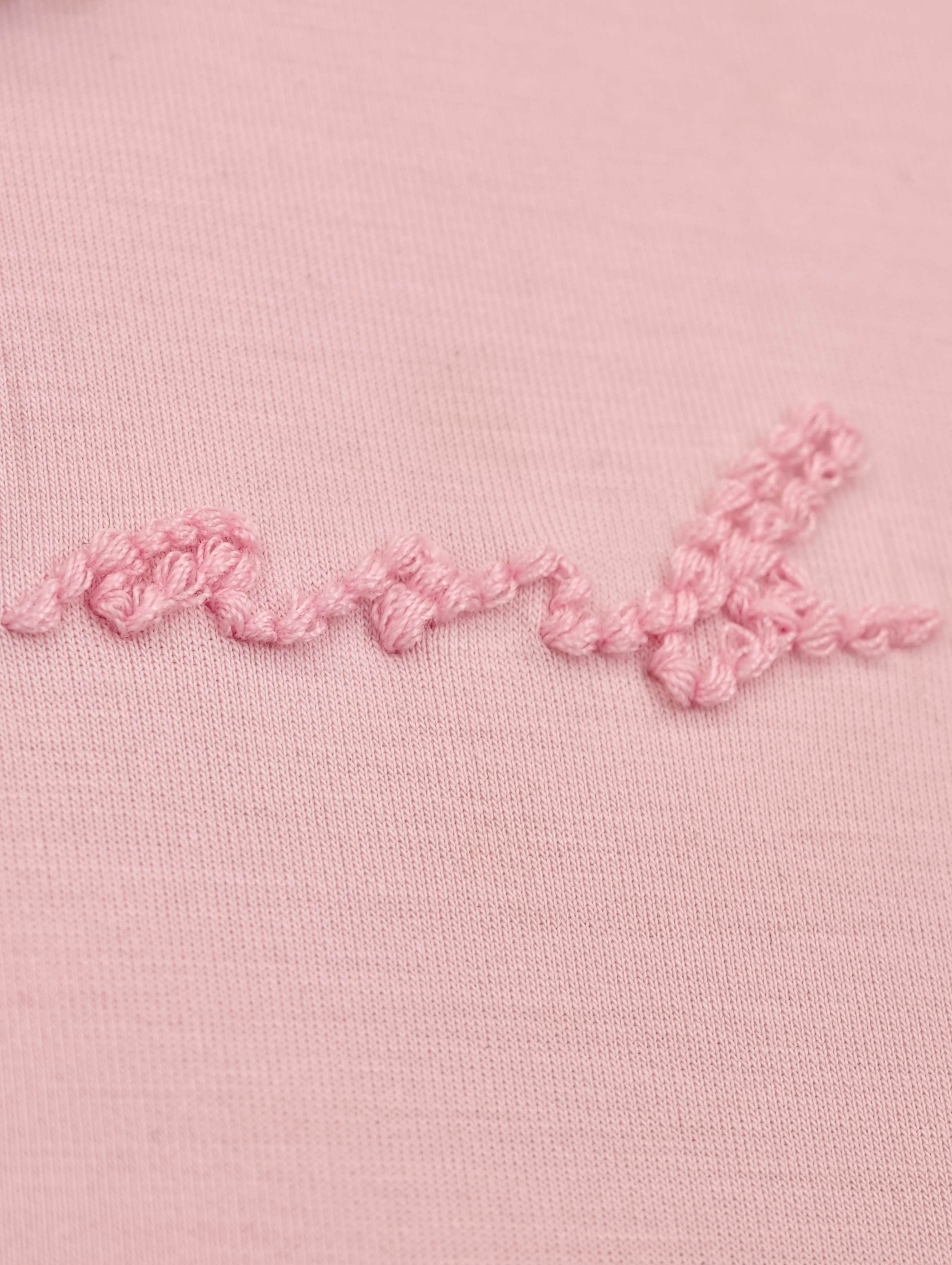 Tonal script embroidery on blush stretch knit fabric