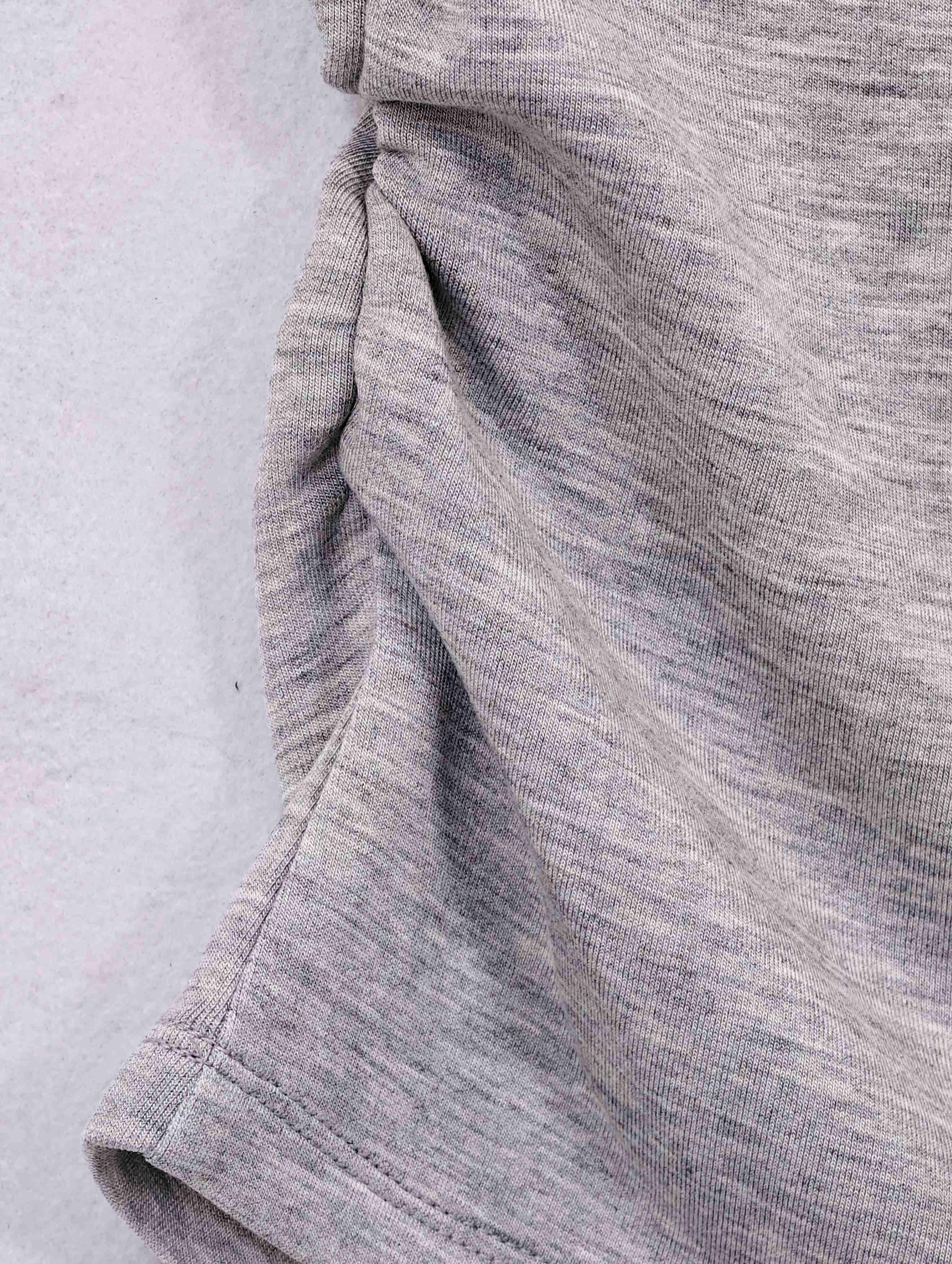 Close-up of ruched side seam on grey knit