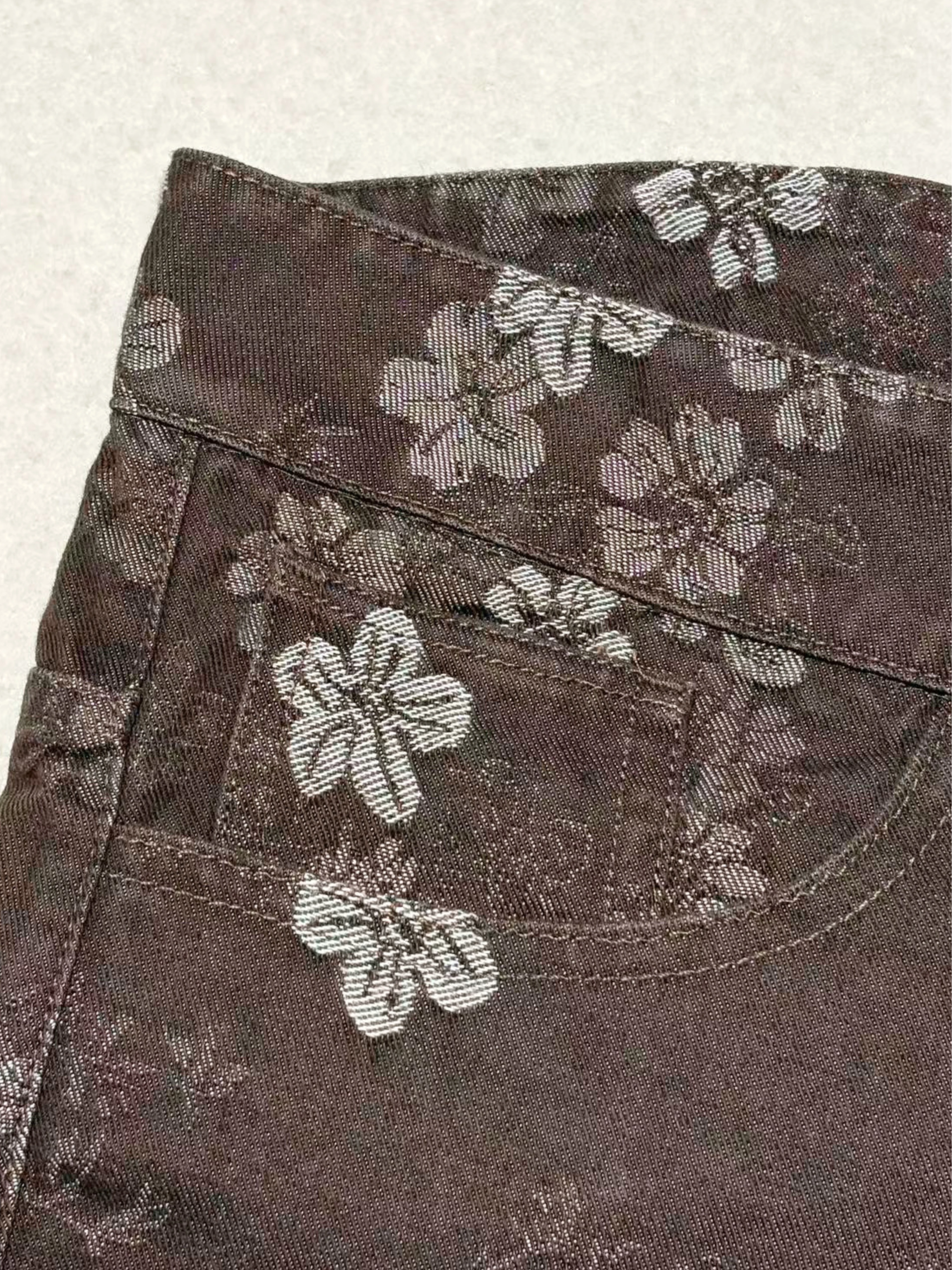 Floral denim waistband and front pocket construction detail