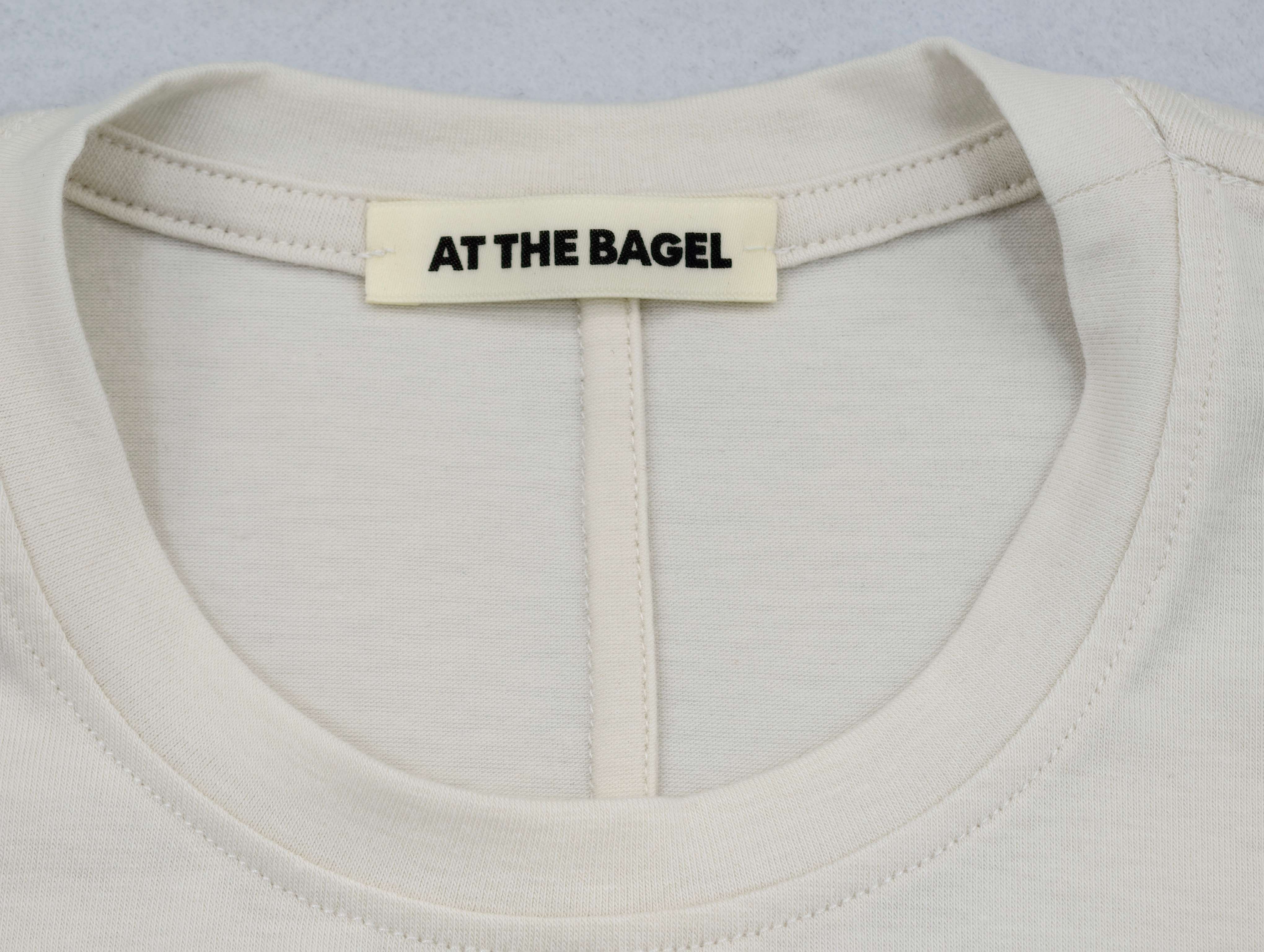 Woven neck label secured above reinforced binding