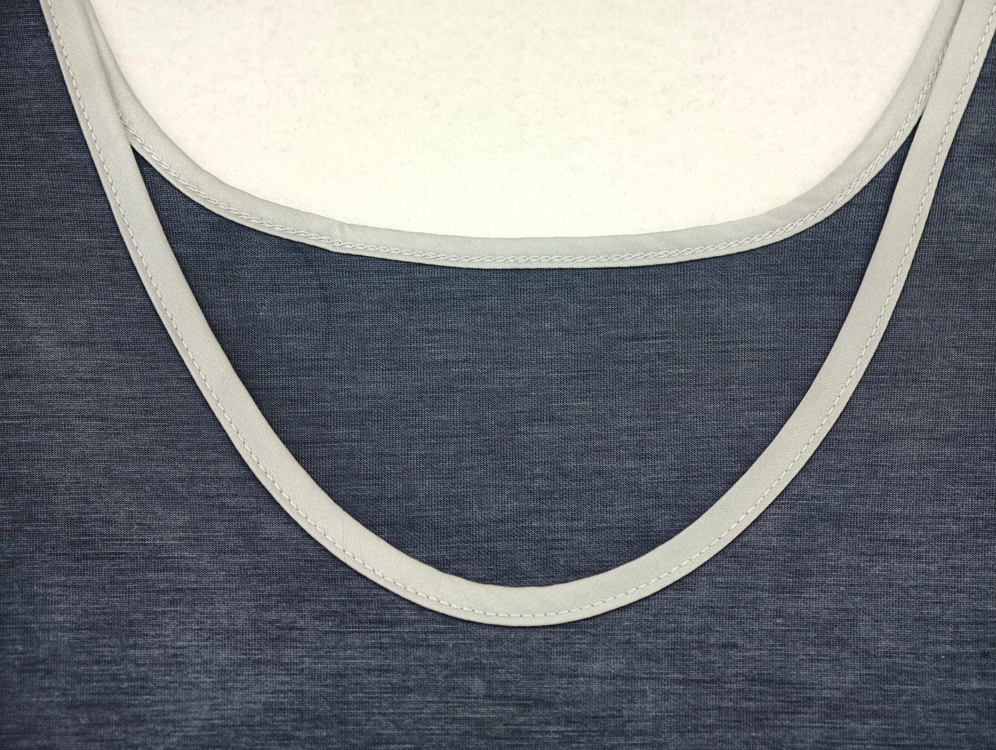 Pale contrast binding around deep scoop neckline