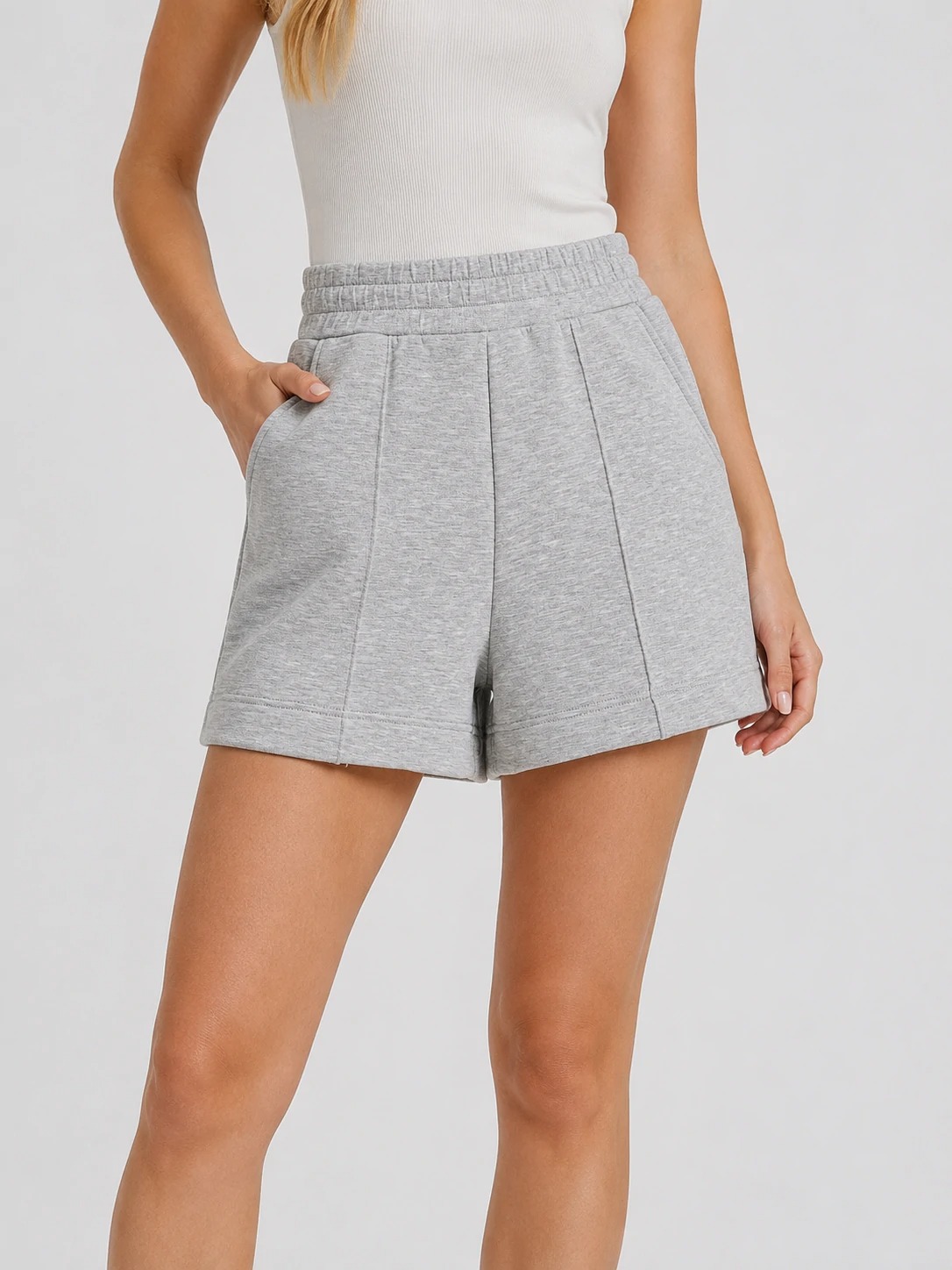 Model wearing heather grey high-waisted pintuck shorts