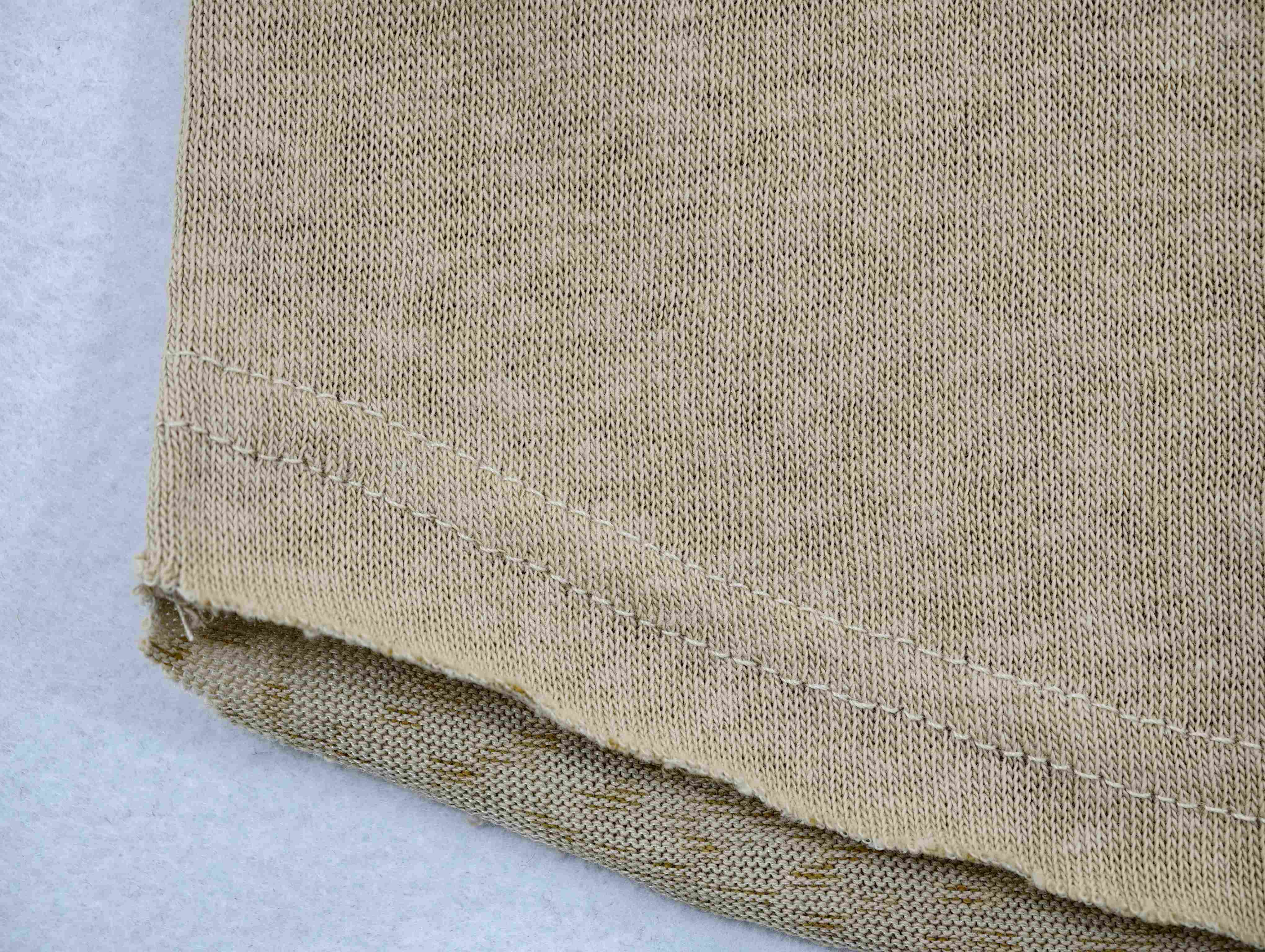 Cotton-linen knit texture beside reinforced raw-edge hem