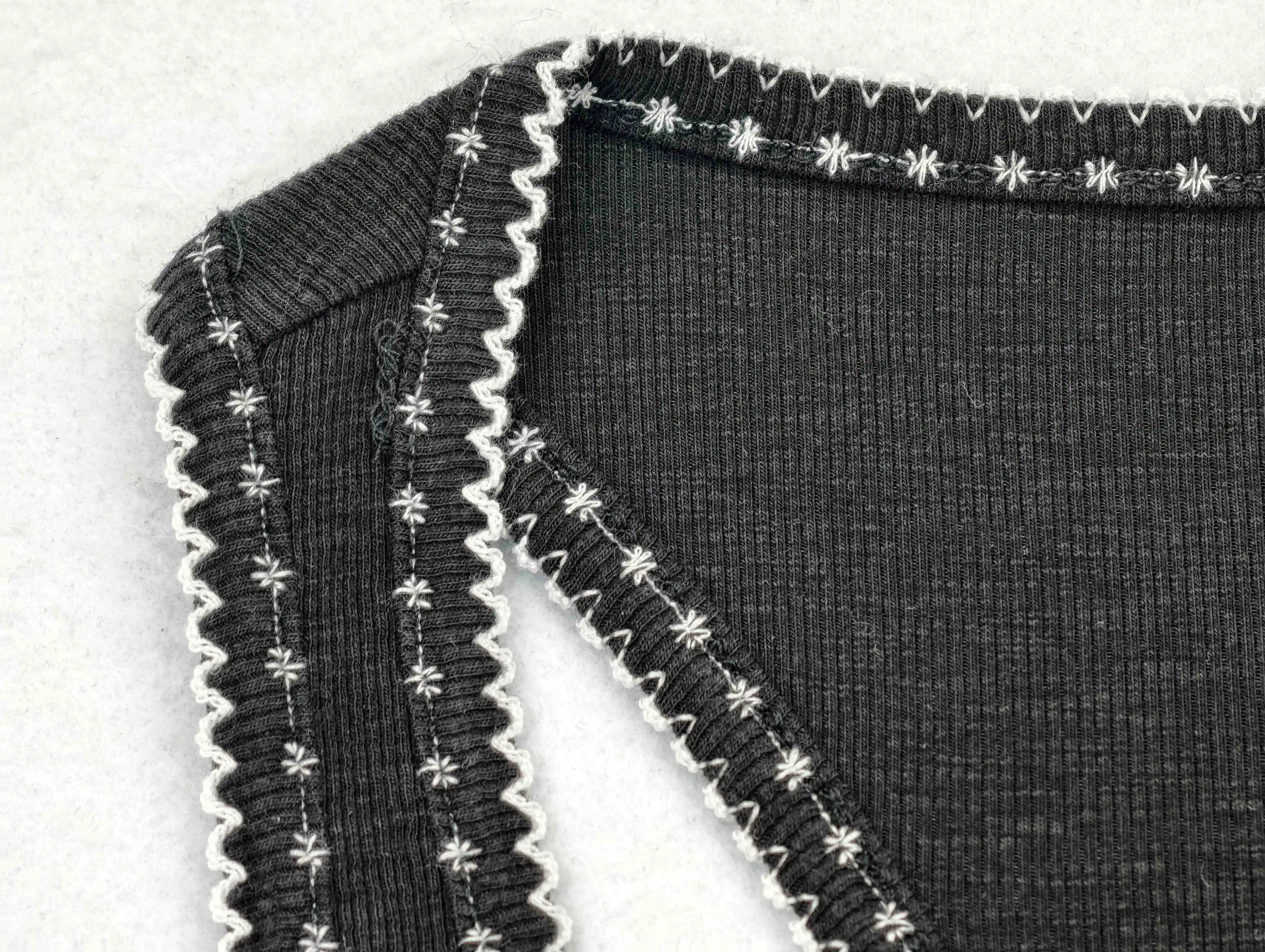 Decorative contrast stitching around neckline and armhole binding