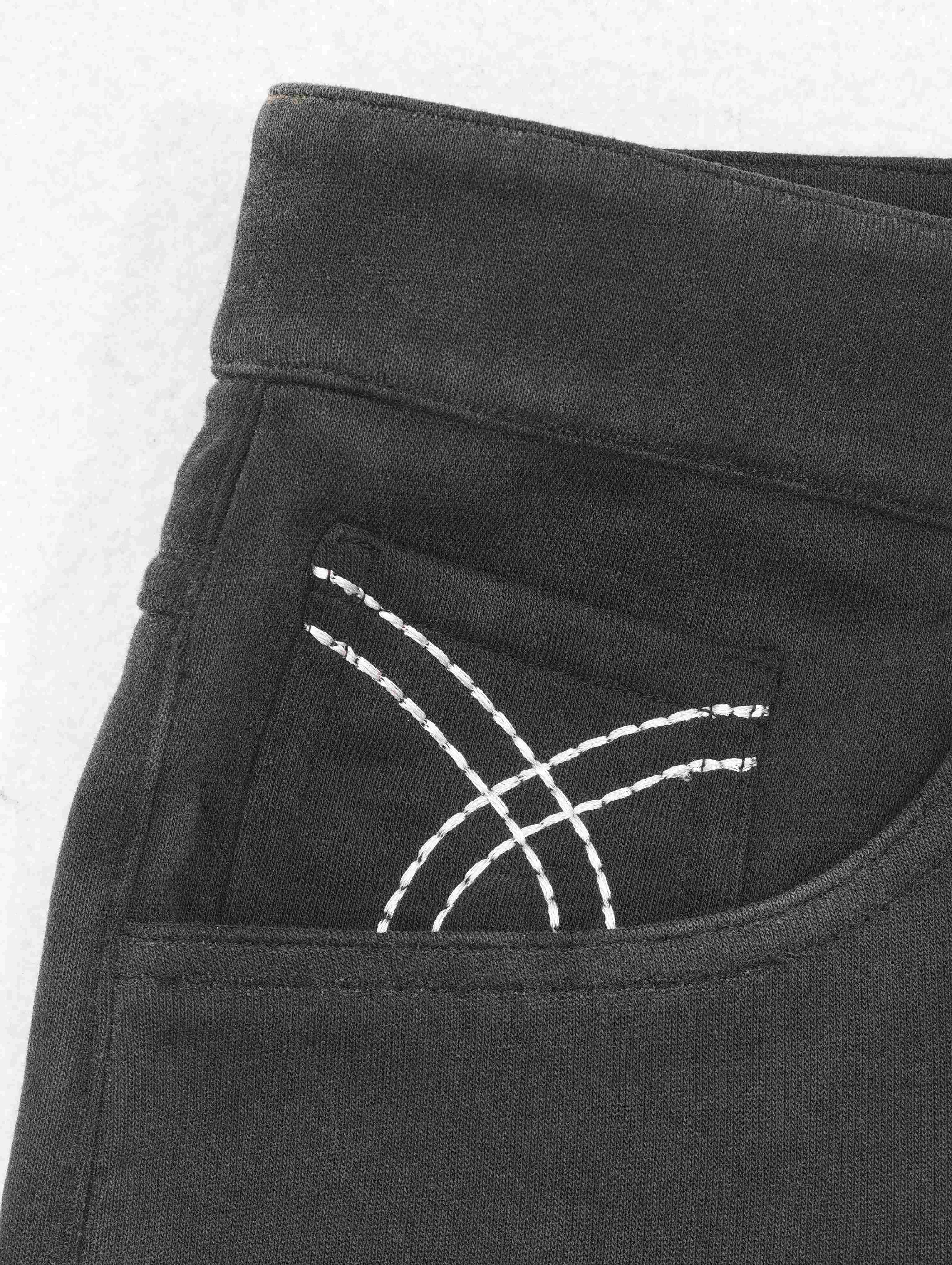 Close-up of embroidered front pocket on charcoal fabric
