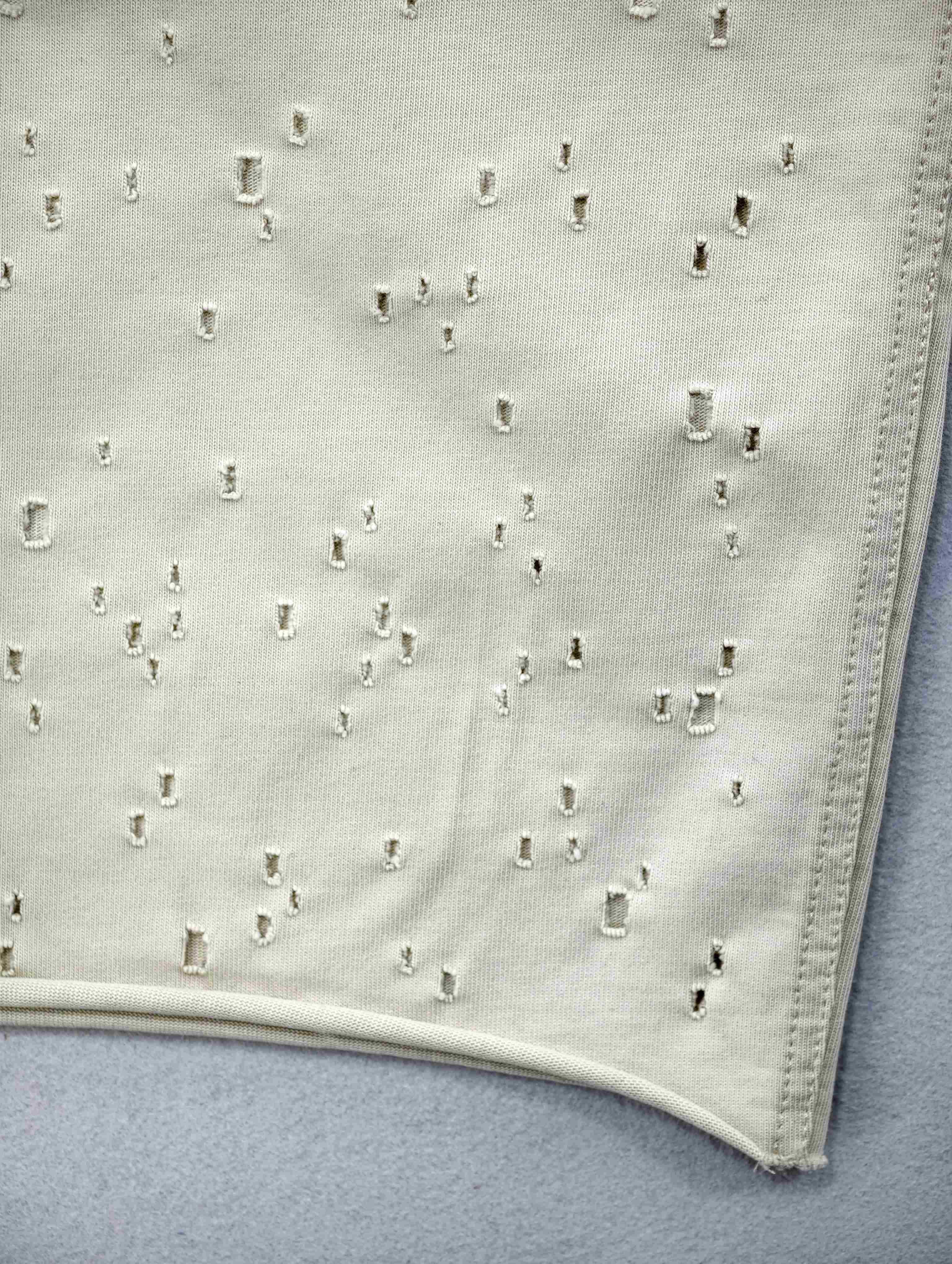 Graduated perforation and raw-look hem close-up