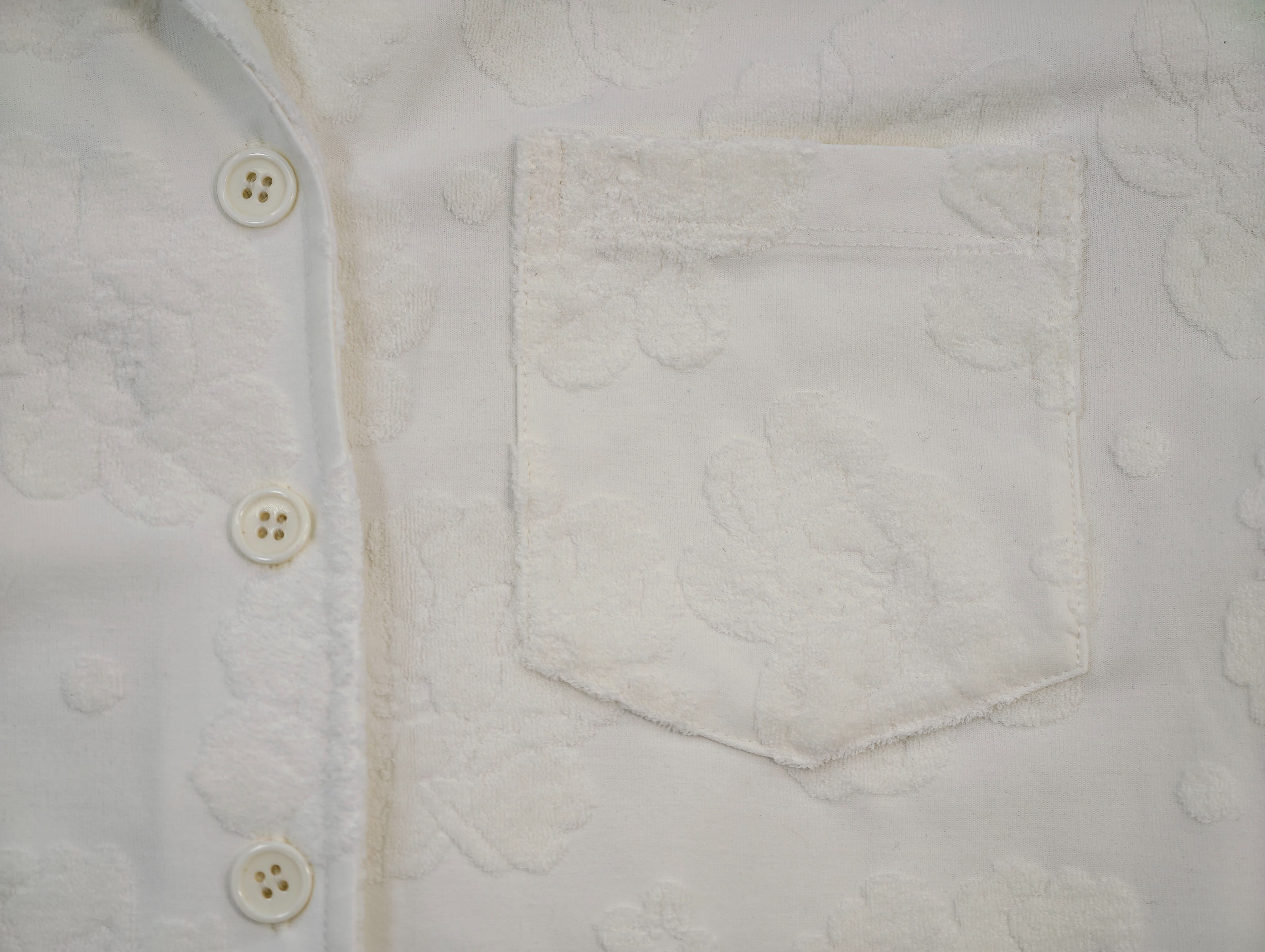Textured floral chest pocket with clean topstitching detail