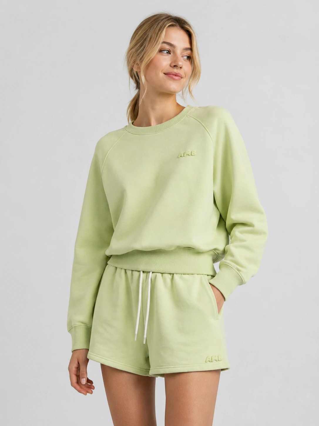 Model wearing light green raglan sweatshirt with matching shorts