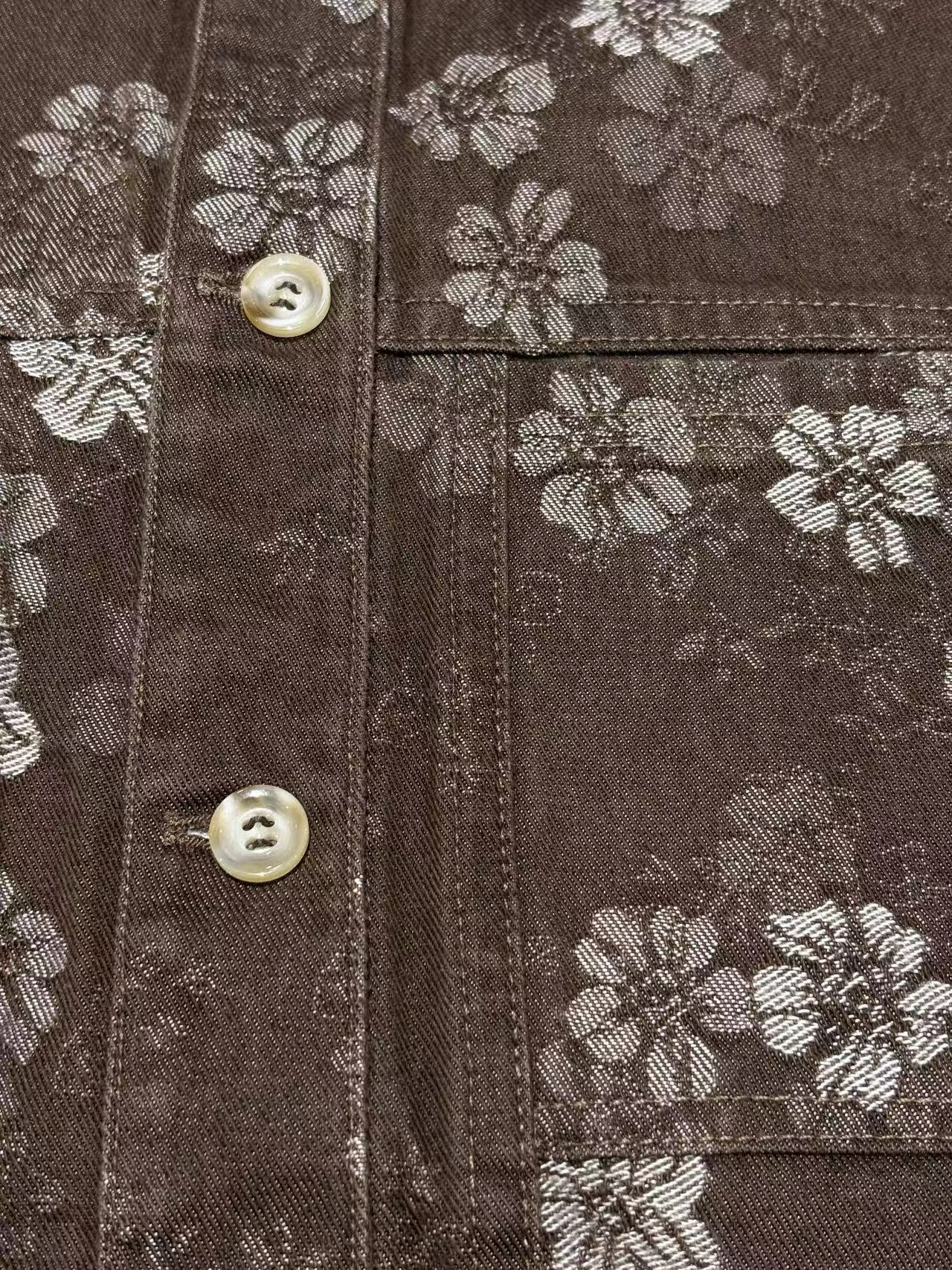 Button placket and chest pocket on printed denim outerwear
