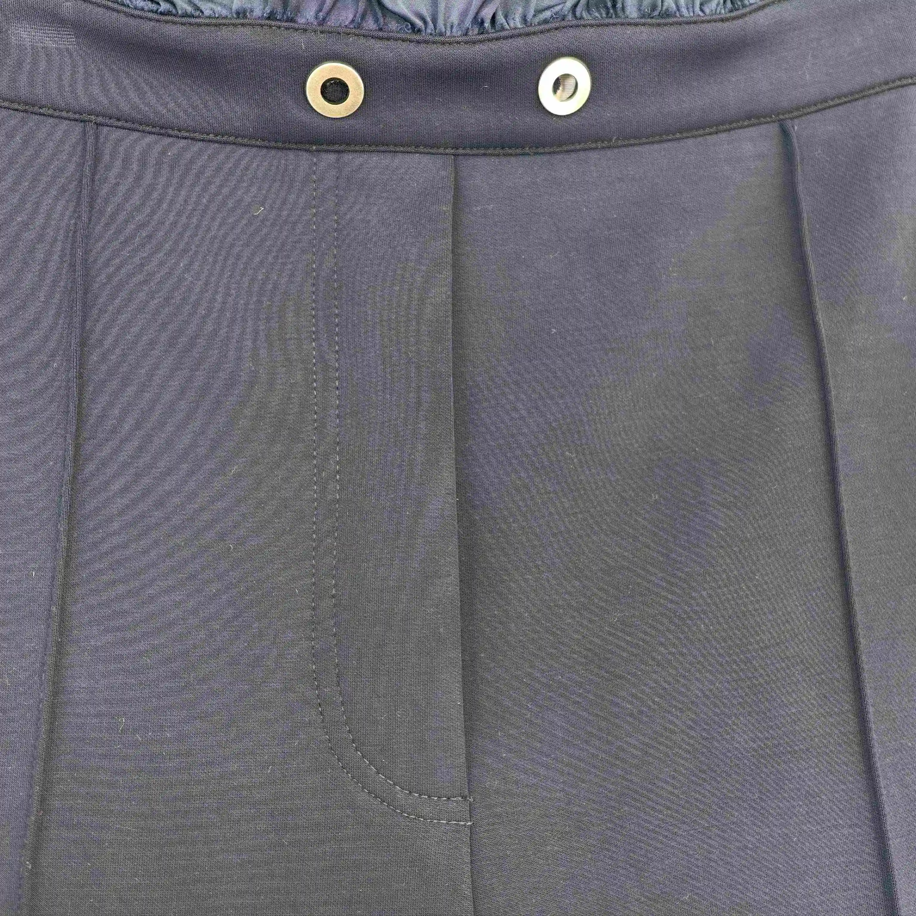 Ruffled waistband, drawcord and metal eyelet close-up