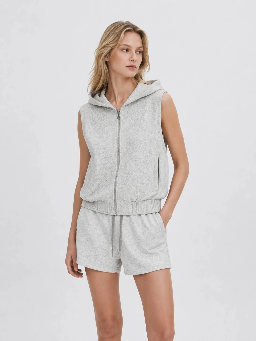 Model wearing light heather grey hooded zip vest