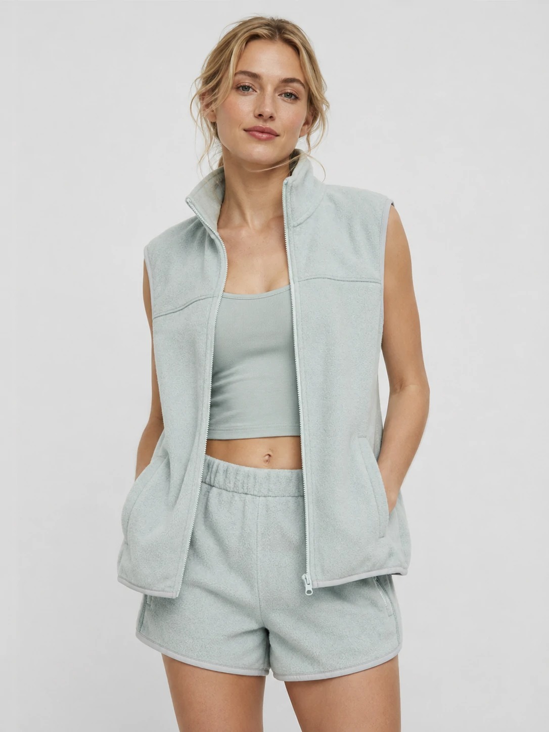 Model wearing light grey recycled fleece zip vest