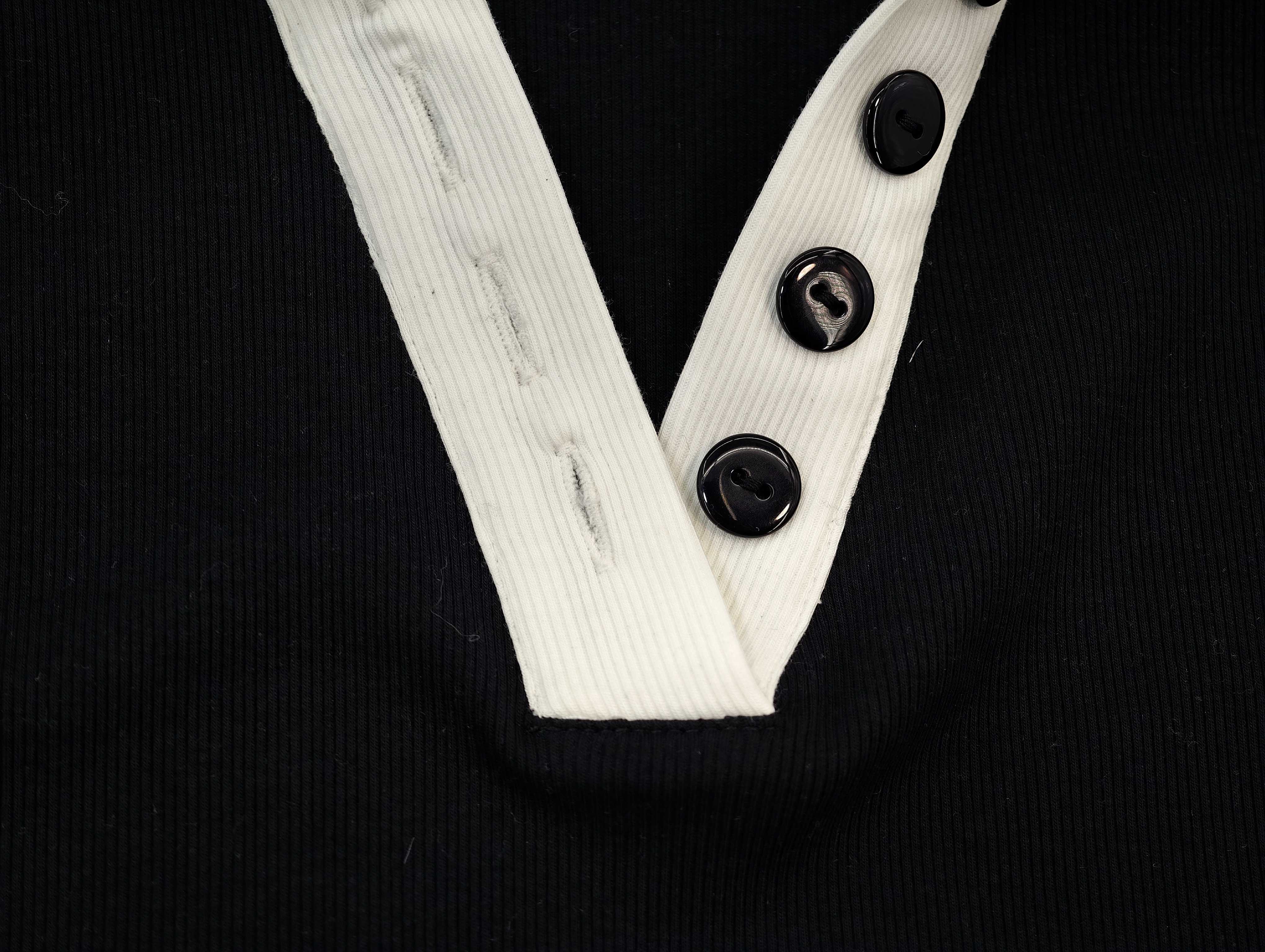 White V-placket with three black button closures