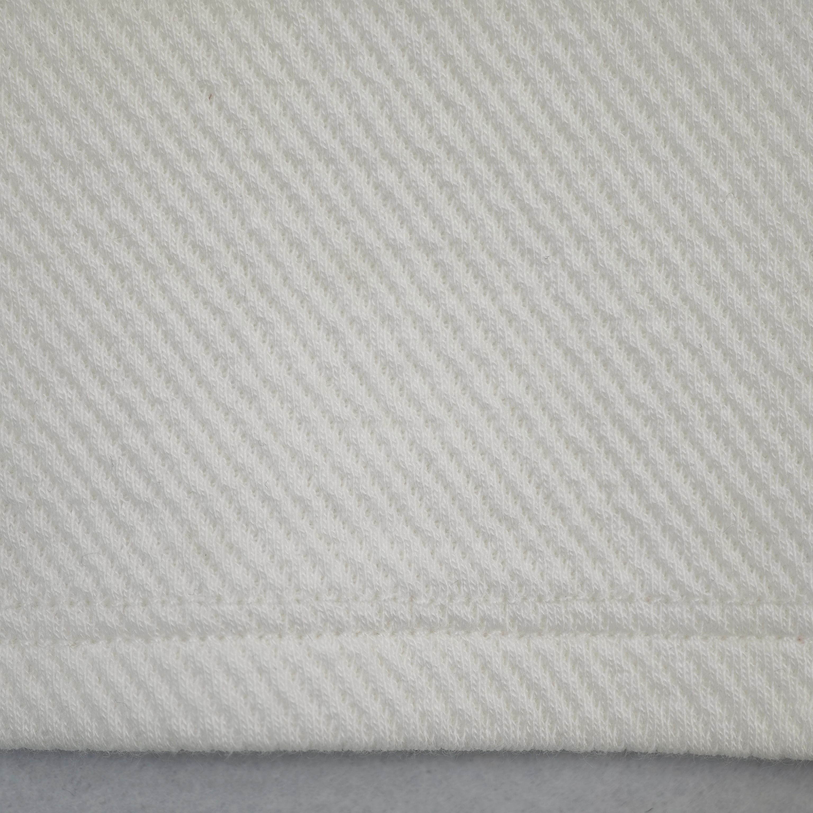 Twill jacquard knit texture and hem stitching detail