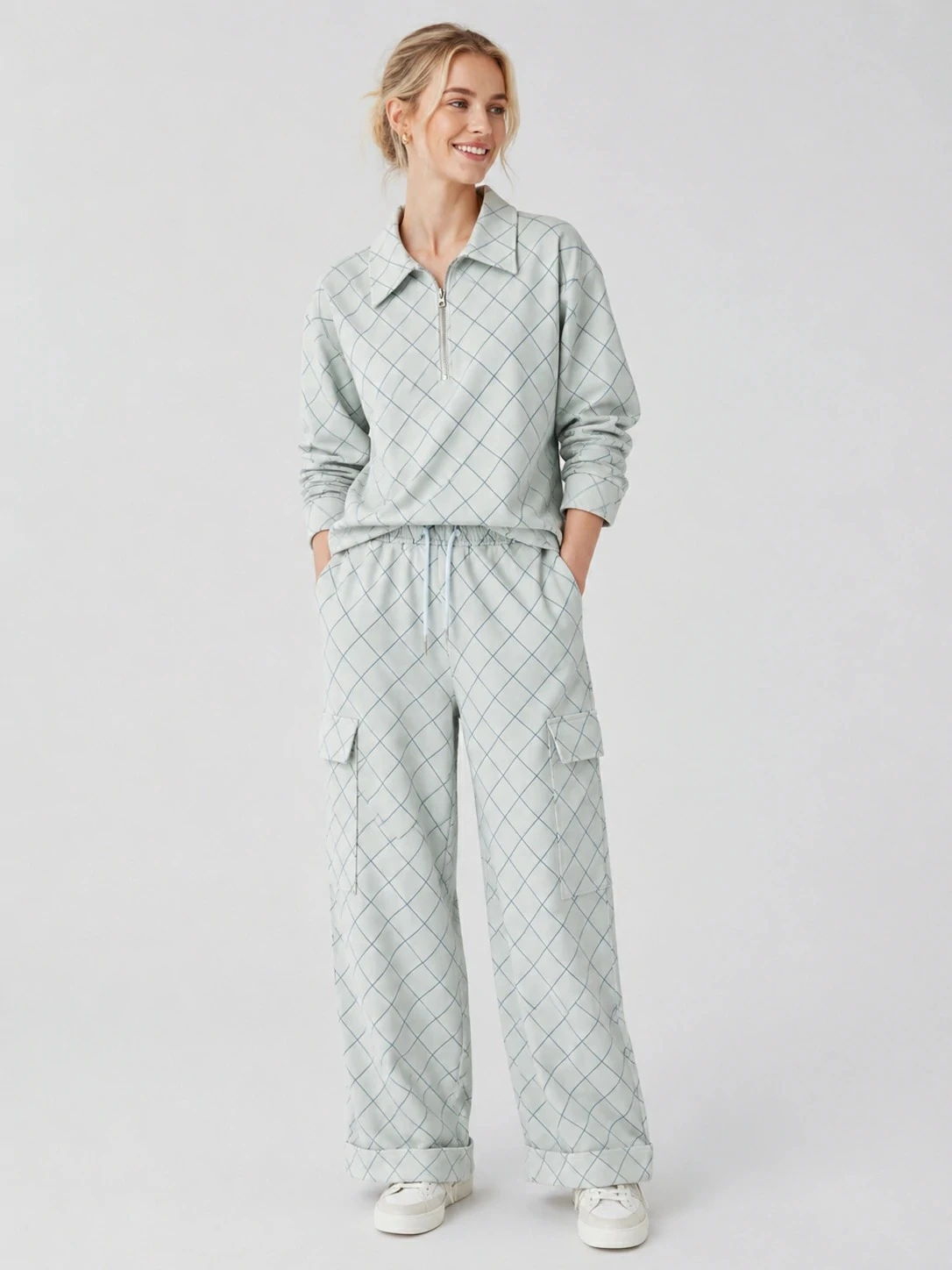 Model wearing pale grey grid-print quarter-zip matching set