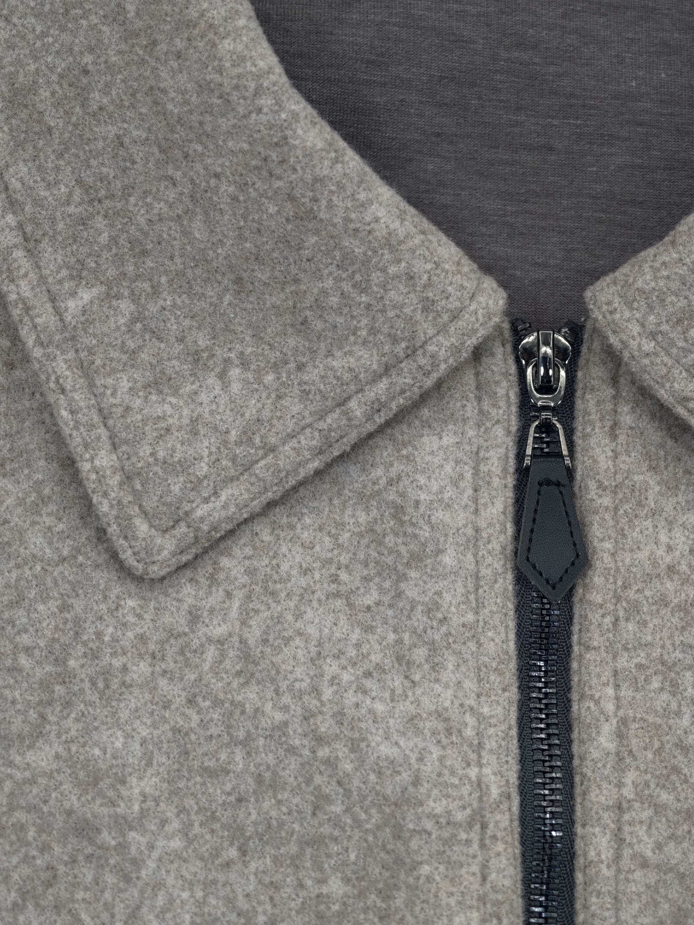 Pointed collar and metal zipper detail from an outerwear supplier