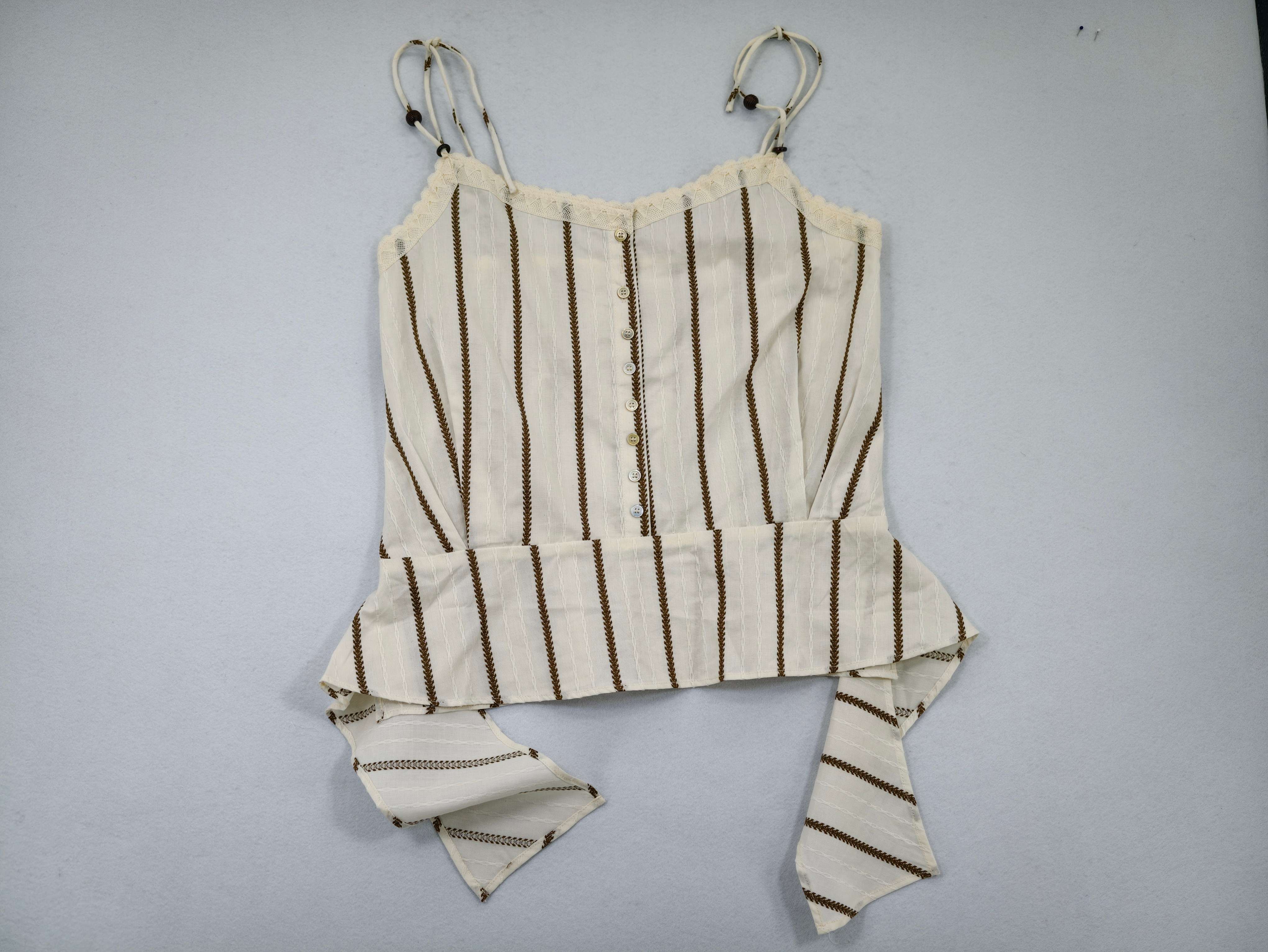 Ivory striped cotton peplum camisole laid flat from front