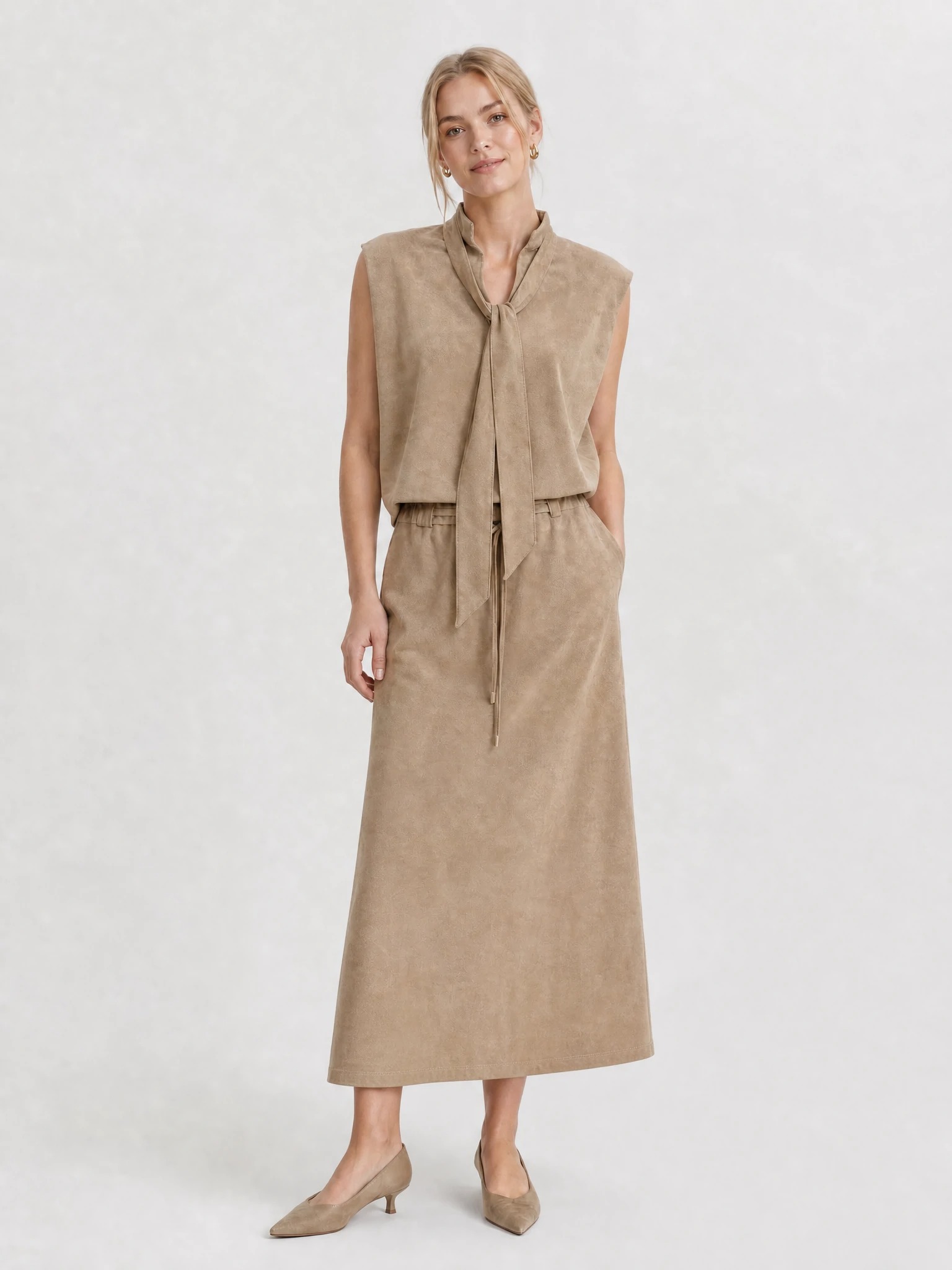 Model wearing taupe tie-neck top and maxi skirt set