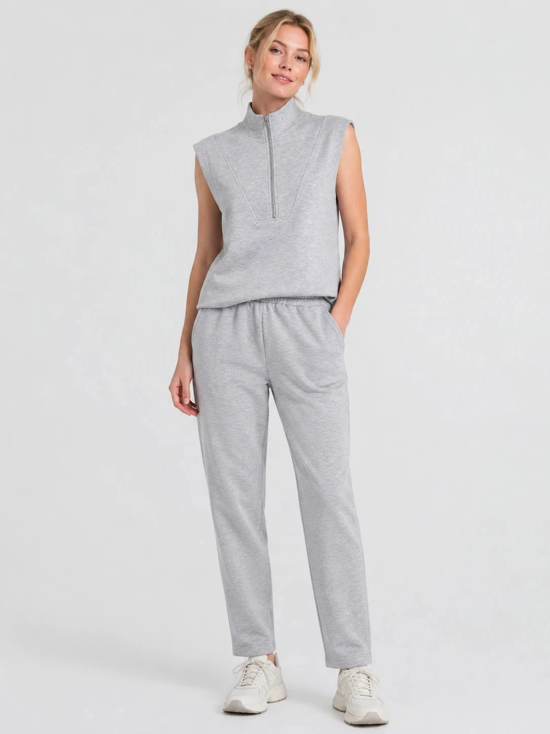 Model wearing grey sleeveless half-zip pullover and matching pants