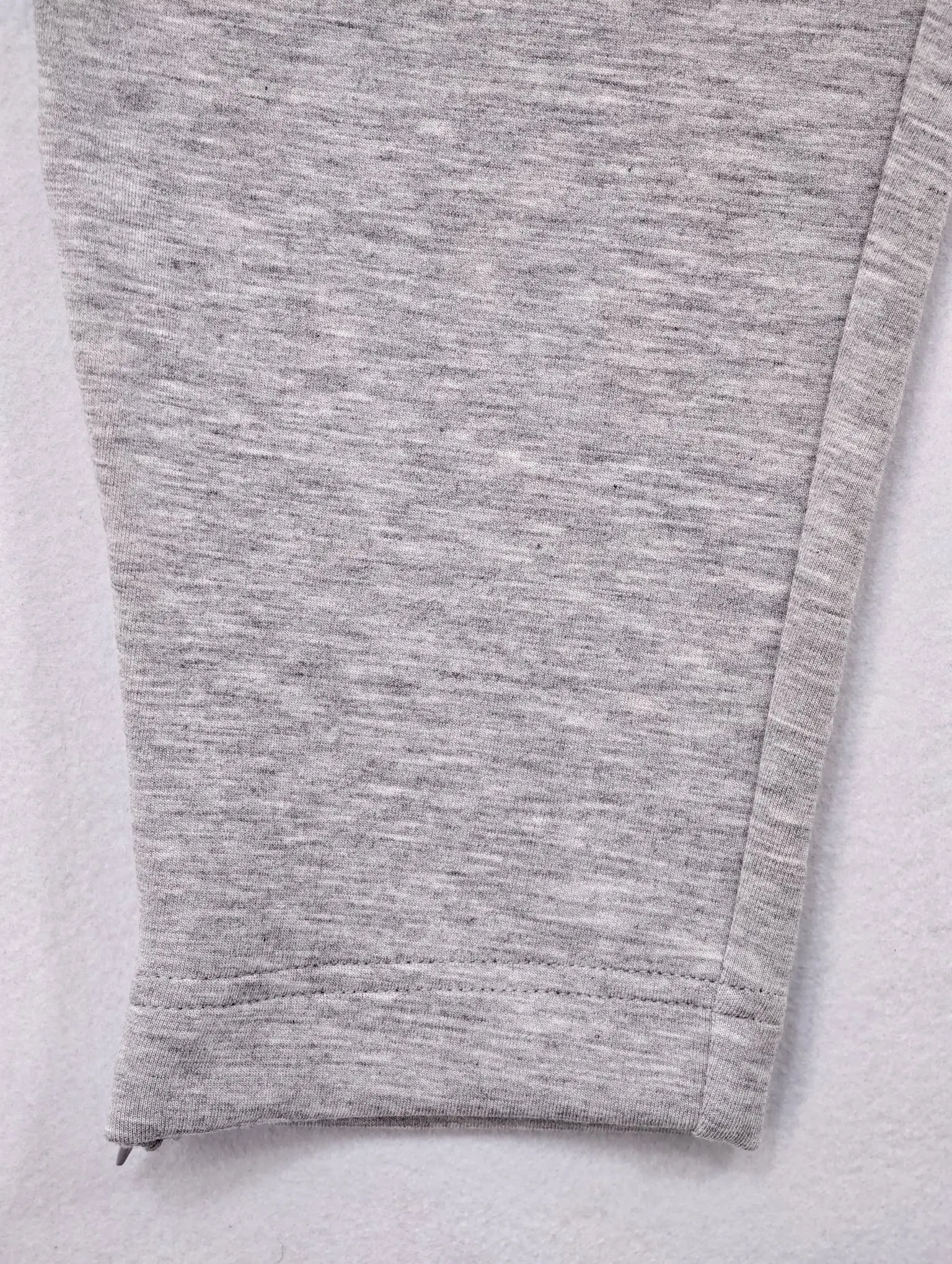 Close-up of tapered leg opening in heather knit fabric