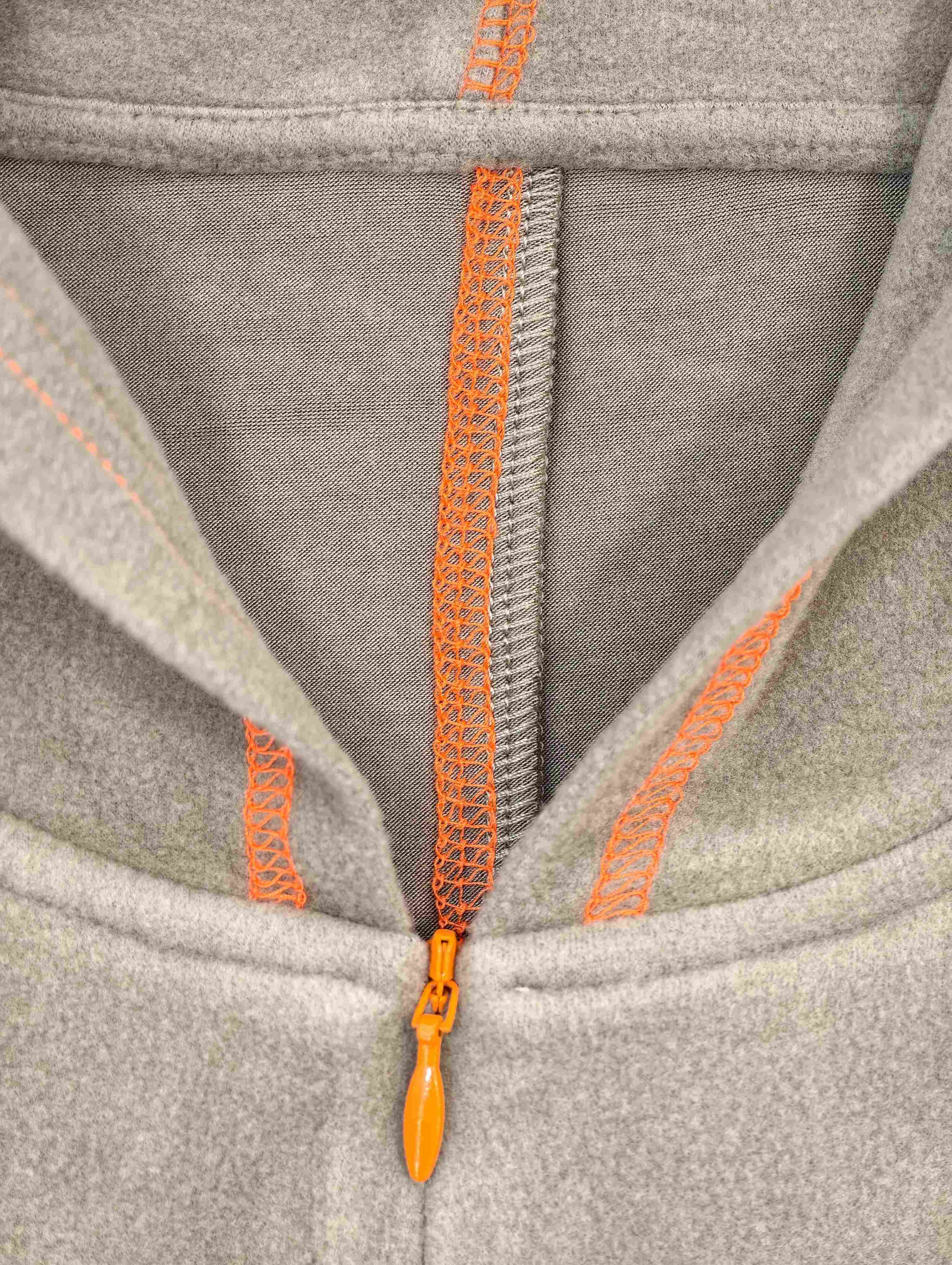 Half-zip neckline and orange coverstitch construction detail