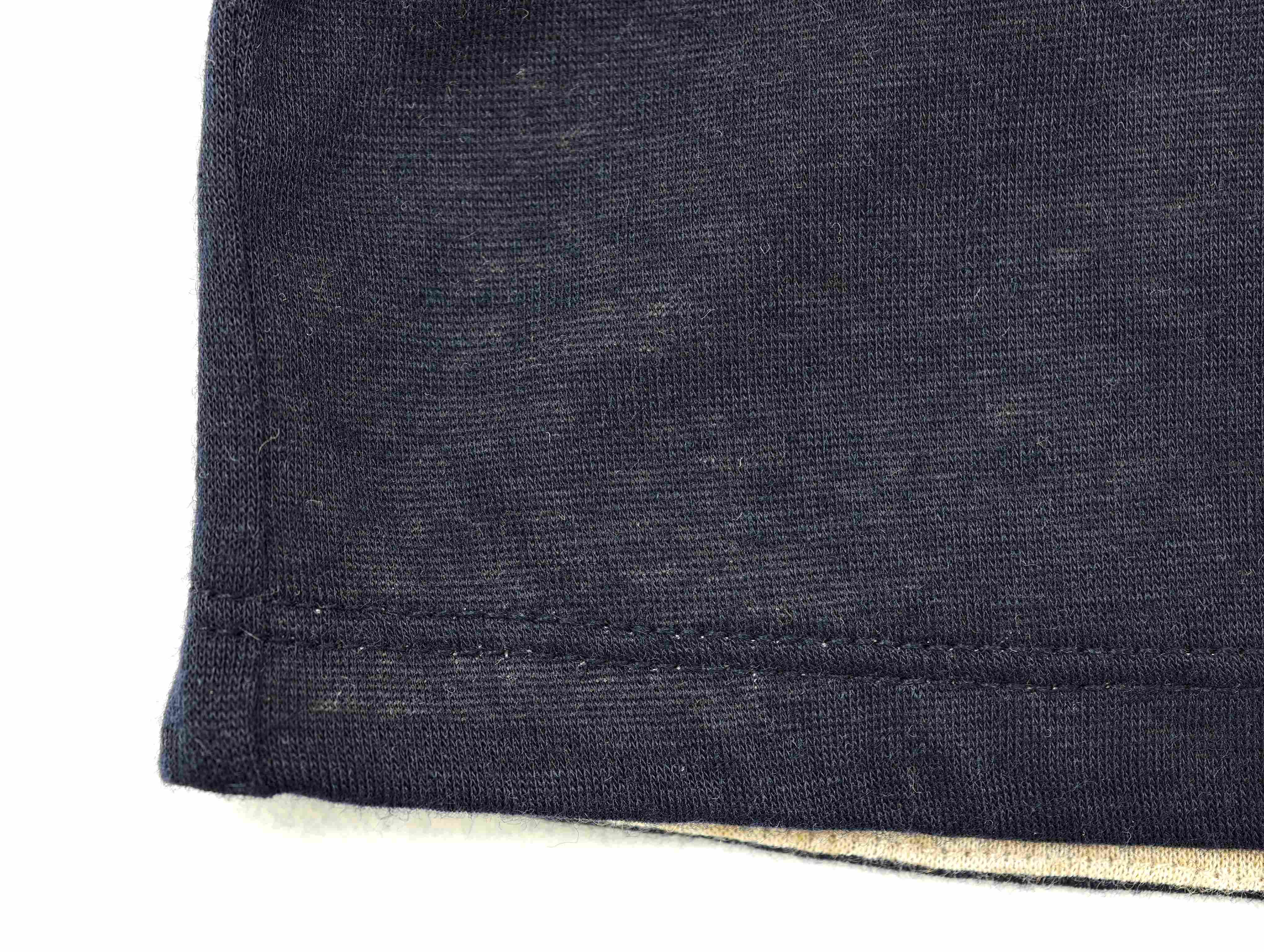 Navy knit texture above pale contrast hem layer