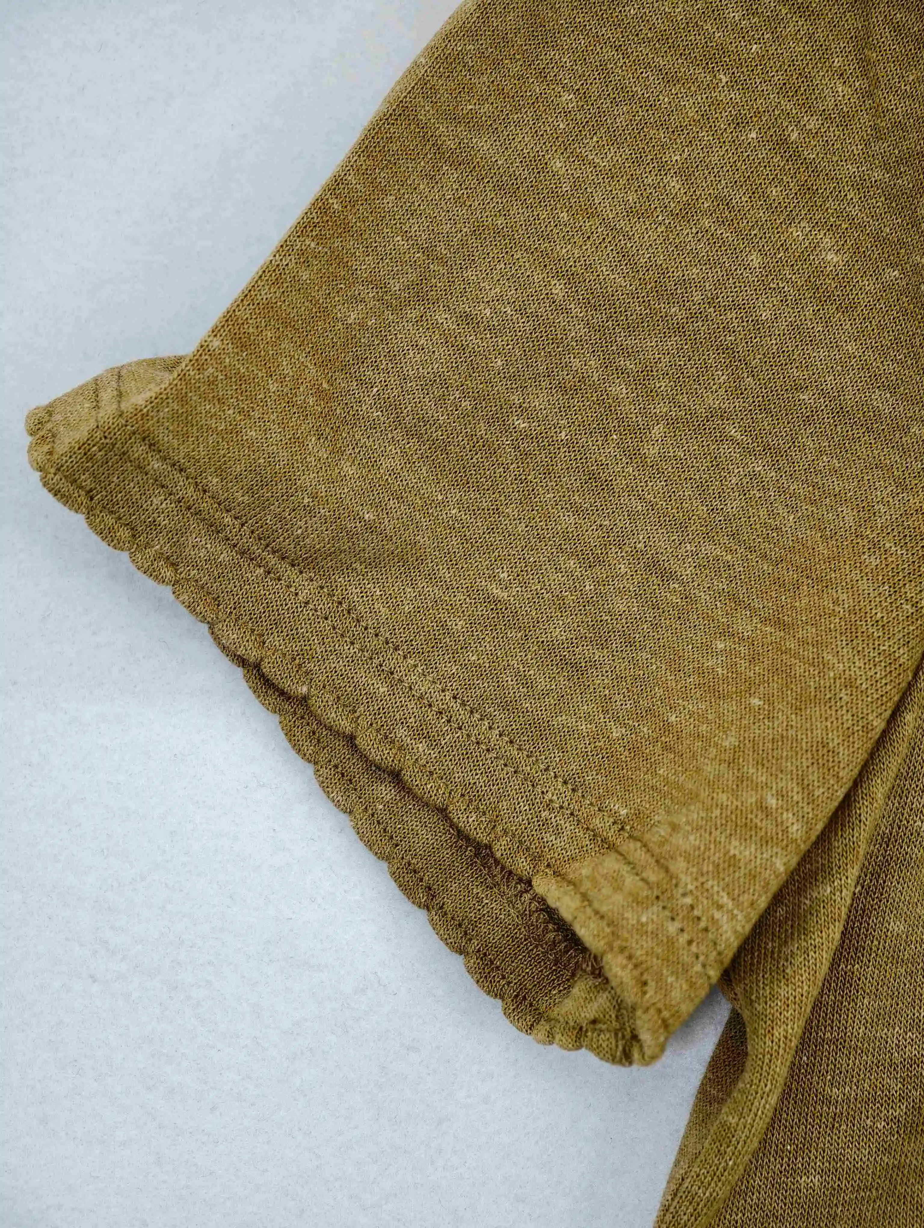 Softly distressed sleeve edge on textured knit fabric