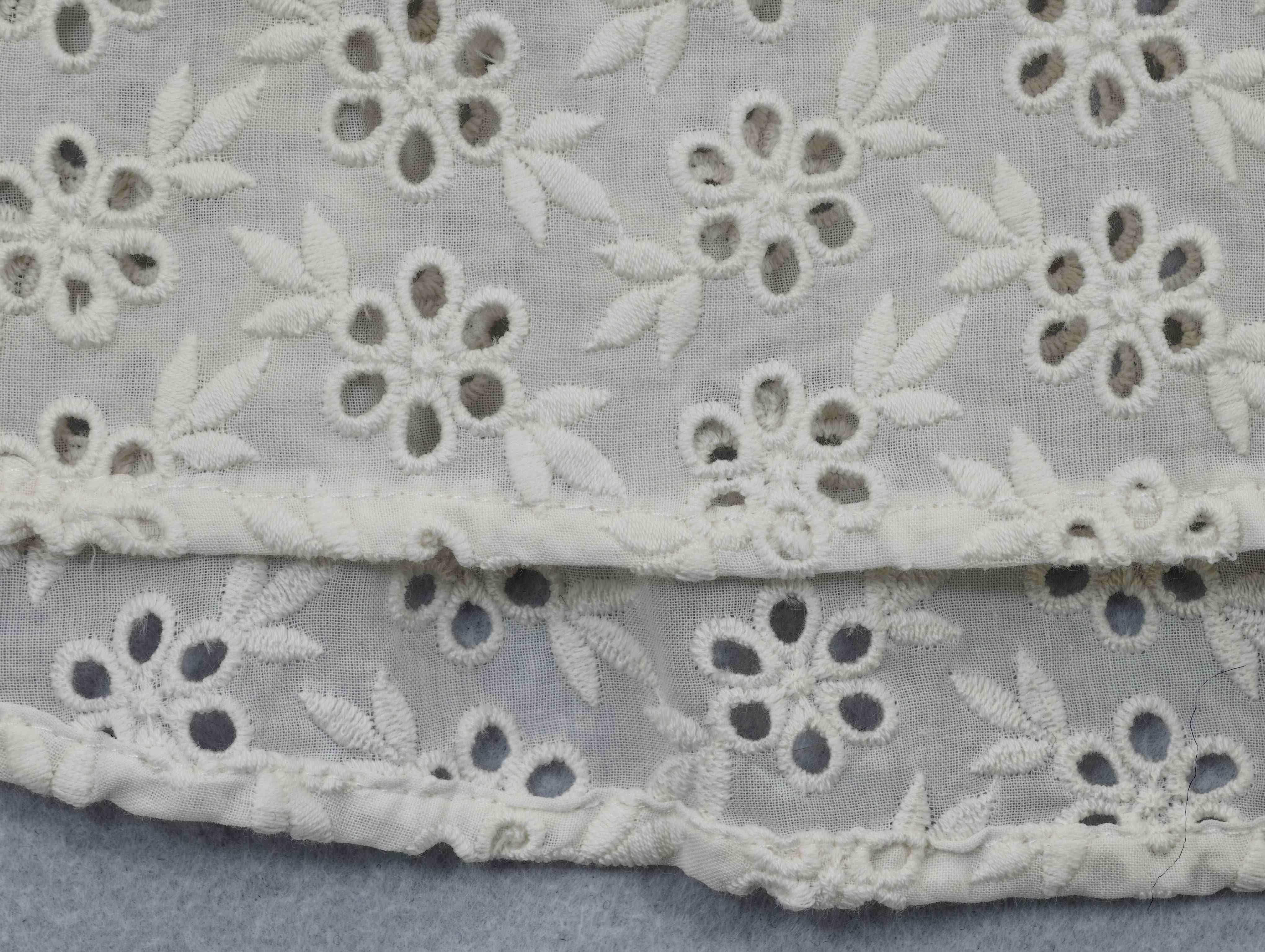 Floral eyelet embroidery and gathered cuff finishing detail