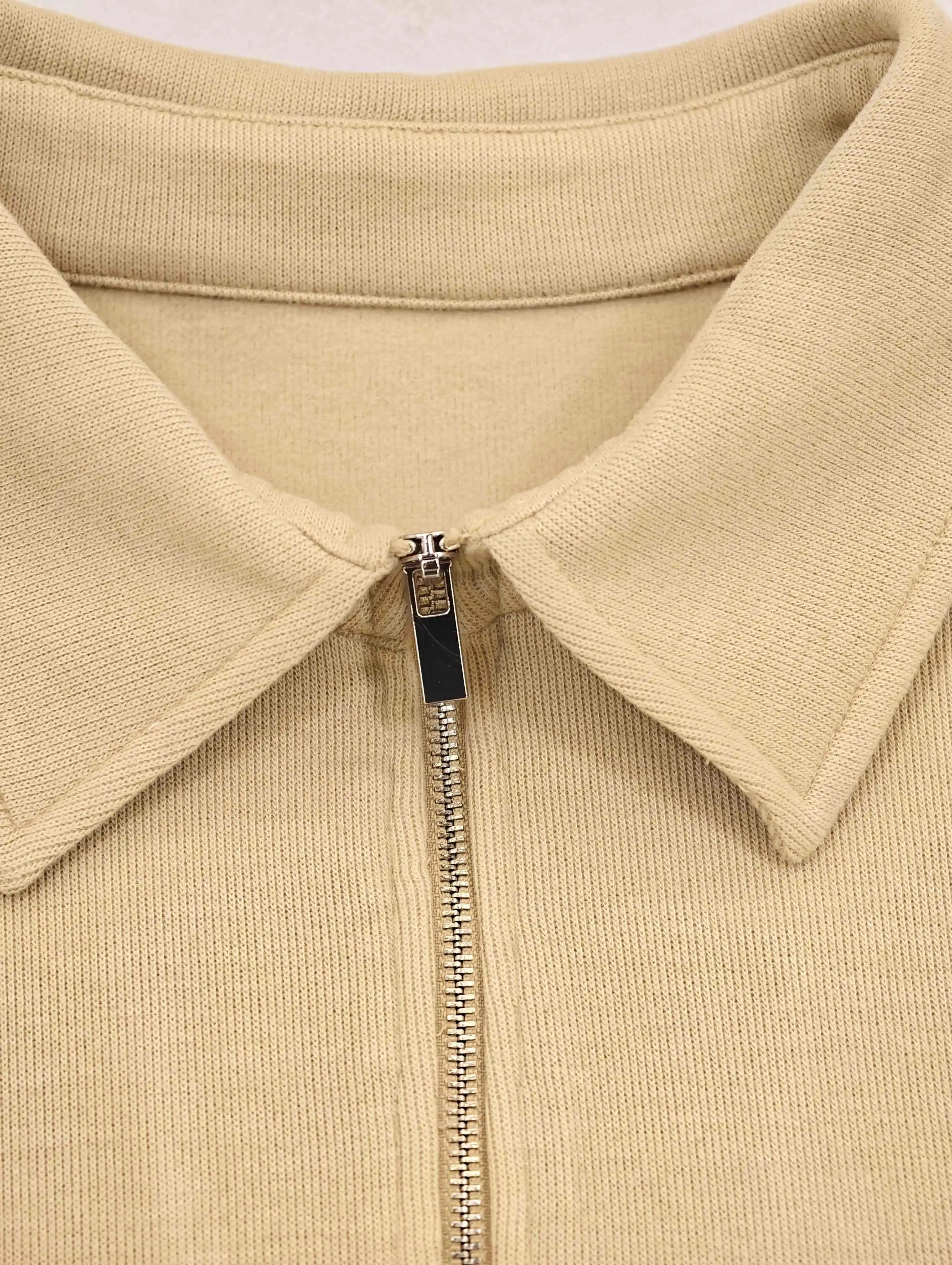 Point collar and metal half-zip closure construction detail